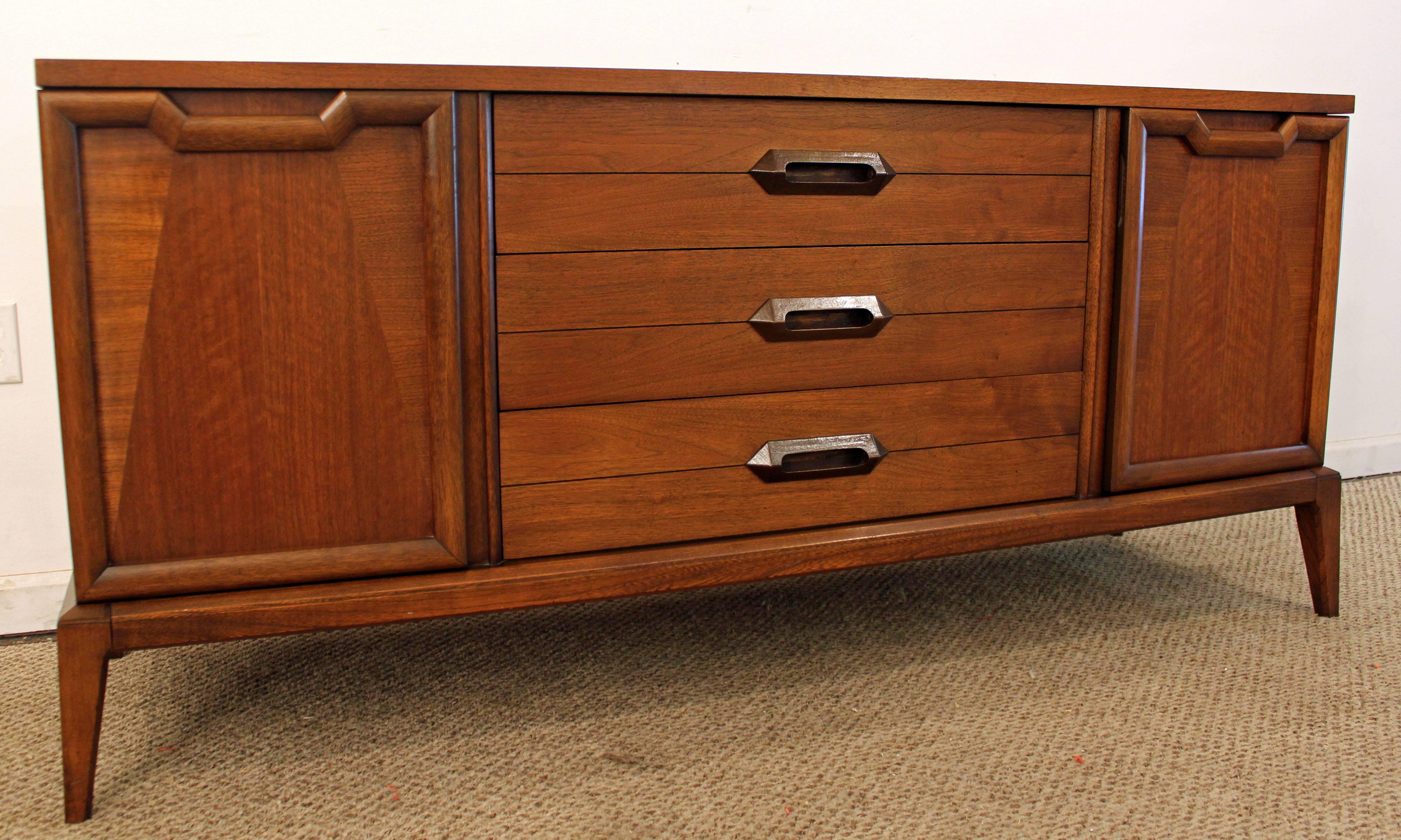 Offered is a walnut credenza by Basic Witz. It has two parqueted doors with shelving inside and three drawers centered. In excellent condition, has been refinished.
