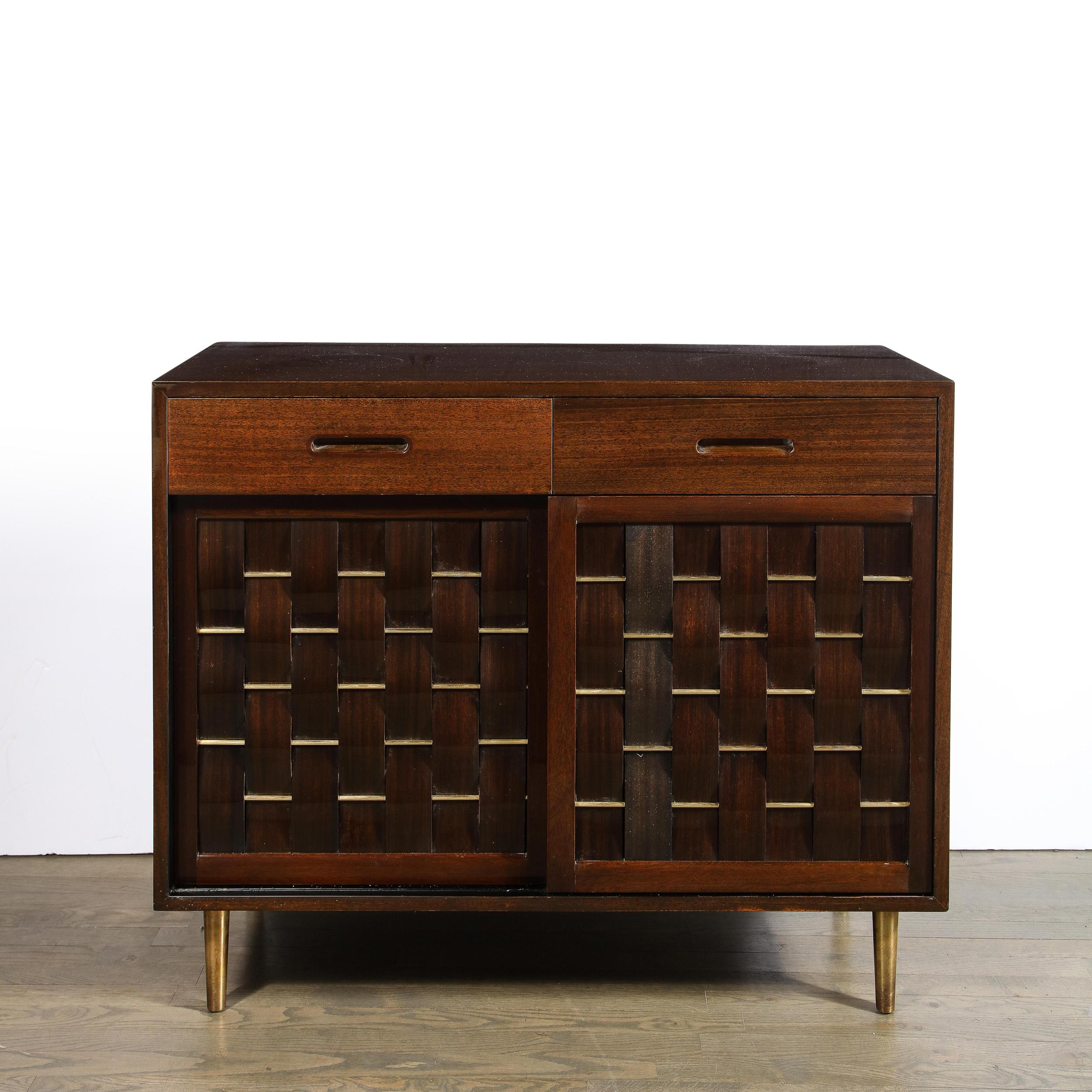 This stunning Mid-Century Modern chest was designed by Edward Wormley for the Dunbar Furniture Company in the United States circa 1955. It features a volumetric rectangular body sitting on four sculptural cylindrical brass legs. The front of the