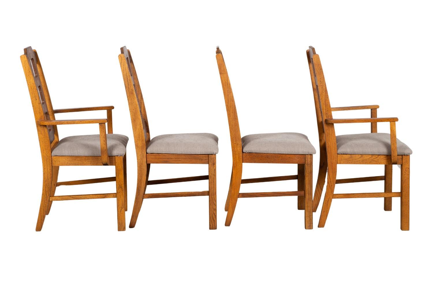 Beautiful set of four Mid Century Modern high back dining chairs by Bassett, 2 side chairs and 2 armchairs. The solid frames feature novel period styling. A sculptural set of modern chairs with high back rests on solid legs. Rich, warm walnut with