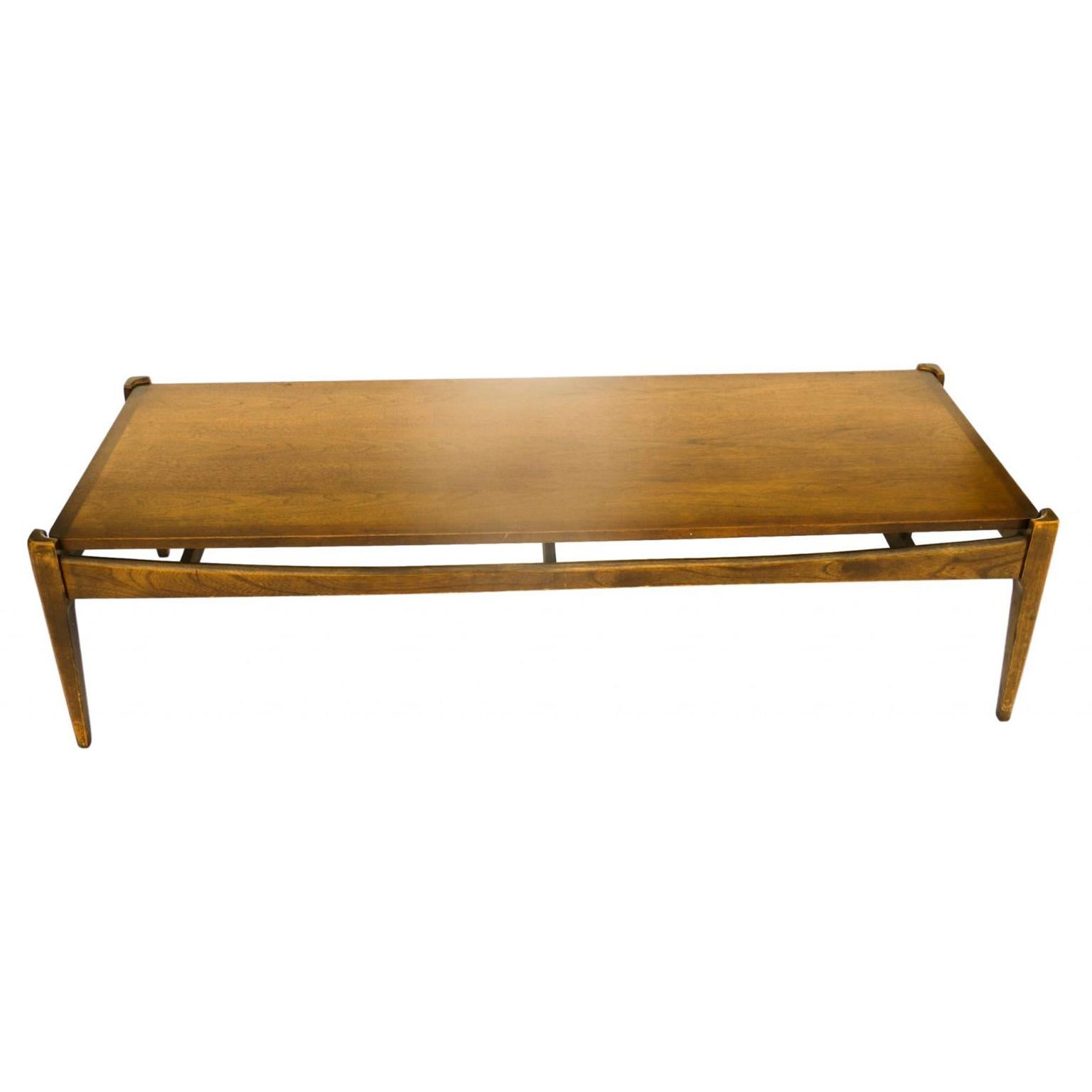 This rare impressive and sleek Mid-Century Modern “Artisan Collection” line coffee table by Bassett was made from the 1960s. It has a great dark walnut color. The lines are clean and elegant. The table is made of solid walnut. Finely tapered pencil
