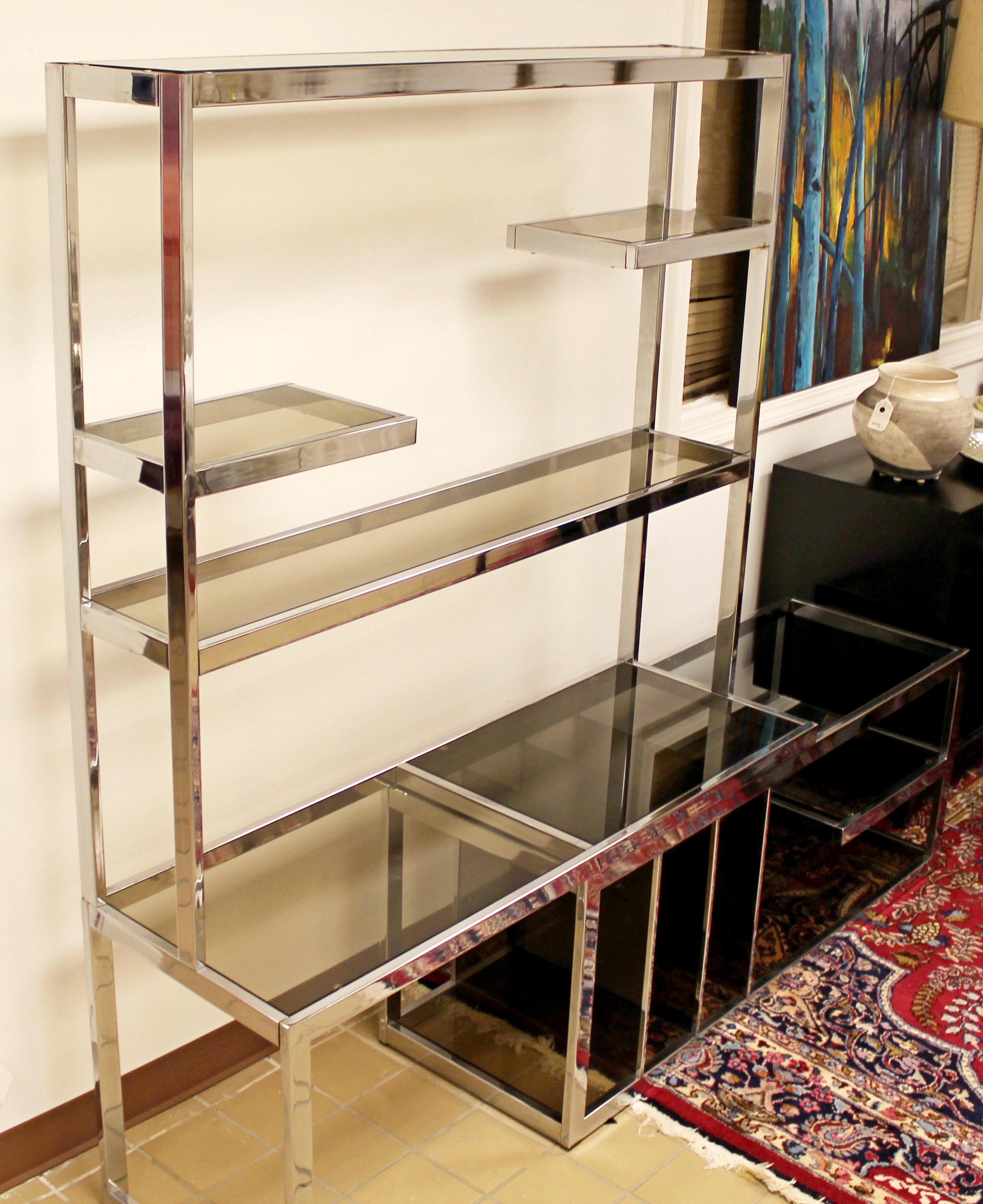 For your consideration is a stunning, chrome étagère, with smoked glass shelves and an expandable storage compartment, by Milo Baughman, circa the 1970s. In excellent condition. The dimensions closed are 50