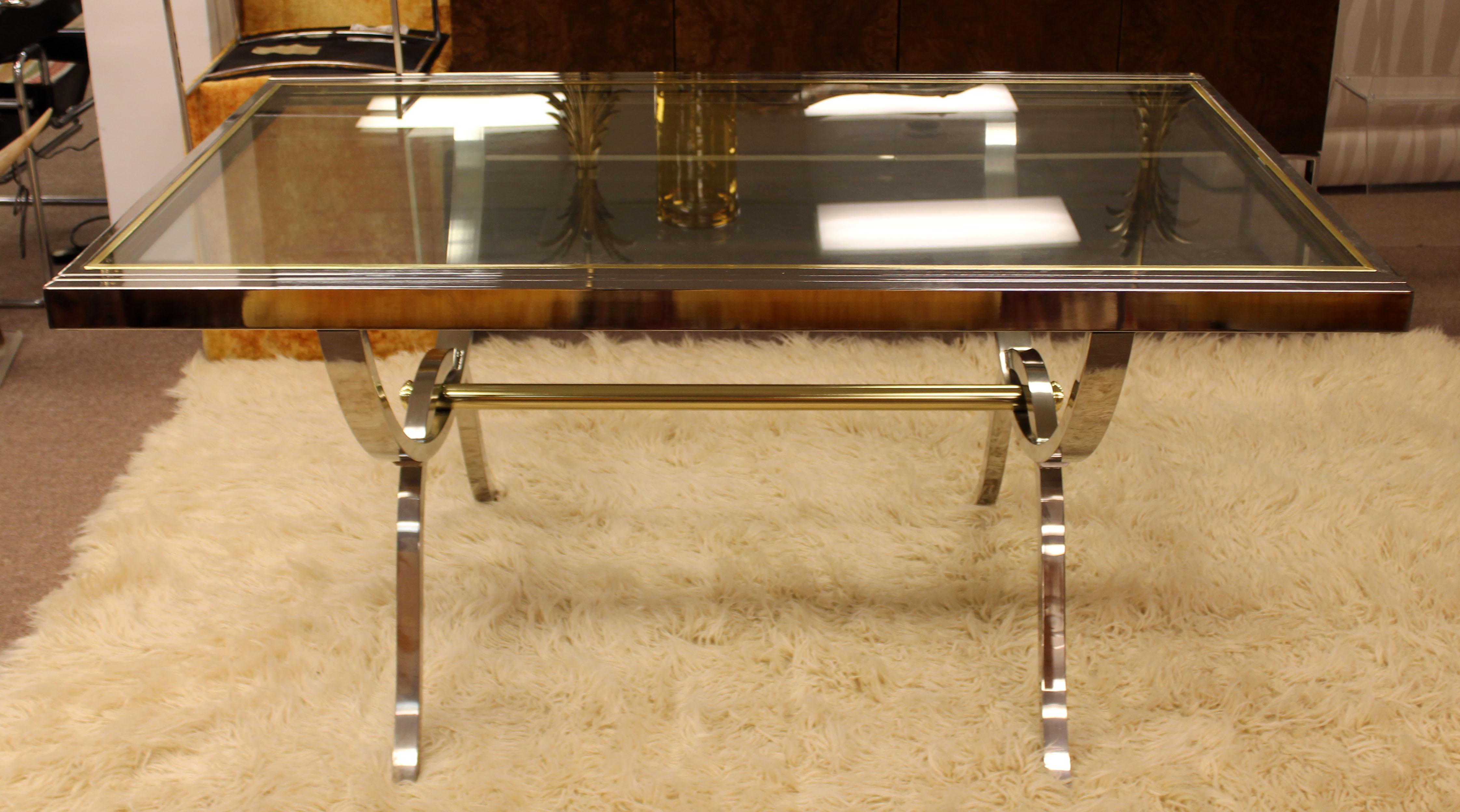 For your consideration is an incredibly luxe and rare extendable dining table, made of chrome and brass and with a glass top, by Milo Baughman for DIA, circa the 1970s. In excellent condition. The dimensions are 60