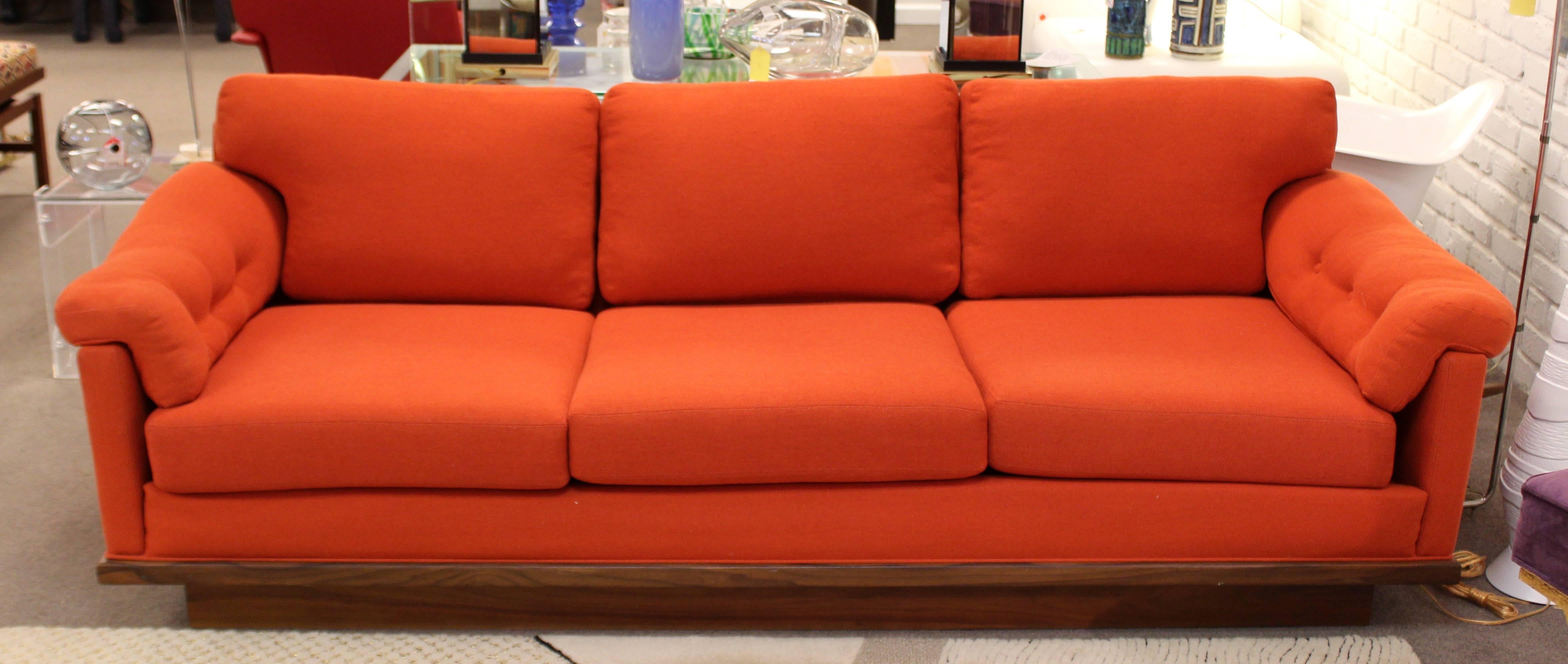 For your consideration is a beautiful, red-orange sofa, on a walnut plinth base by Milo Baughman, circa 1960s. Cushions have been newly re-foamed. In excellent condition. The dimensions are 82