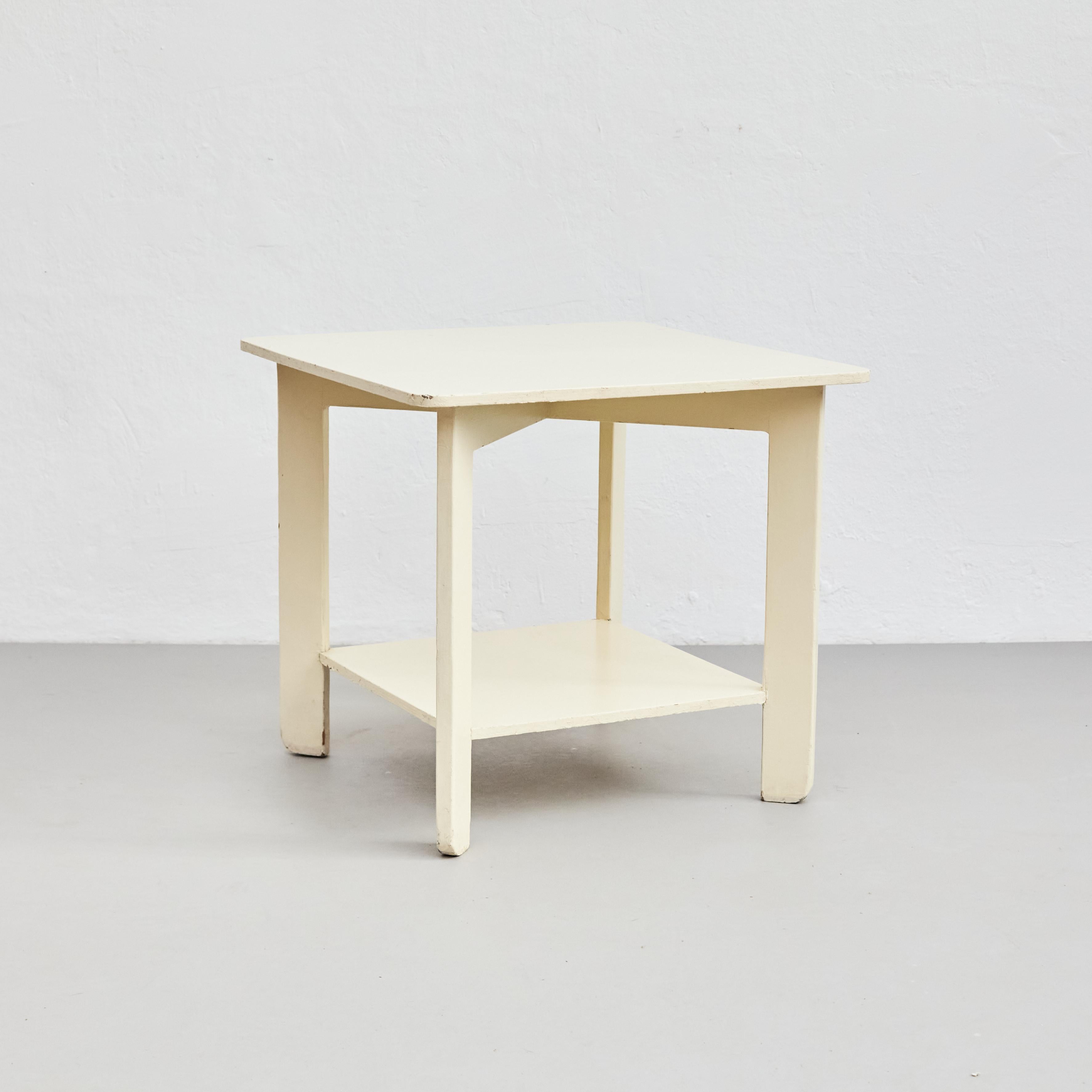 Table basse laquée blanche de style Bauhaus.    Fabriqué en Allemagne, vers 1960.    En état d'origine avec une usure mineure conforme à l'âge et à l'utilisation, préservant une belle patine.    Matériaux :   Bois     Dimensions :   P 55 cm x L 55