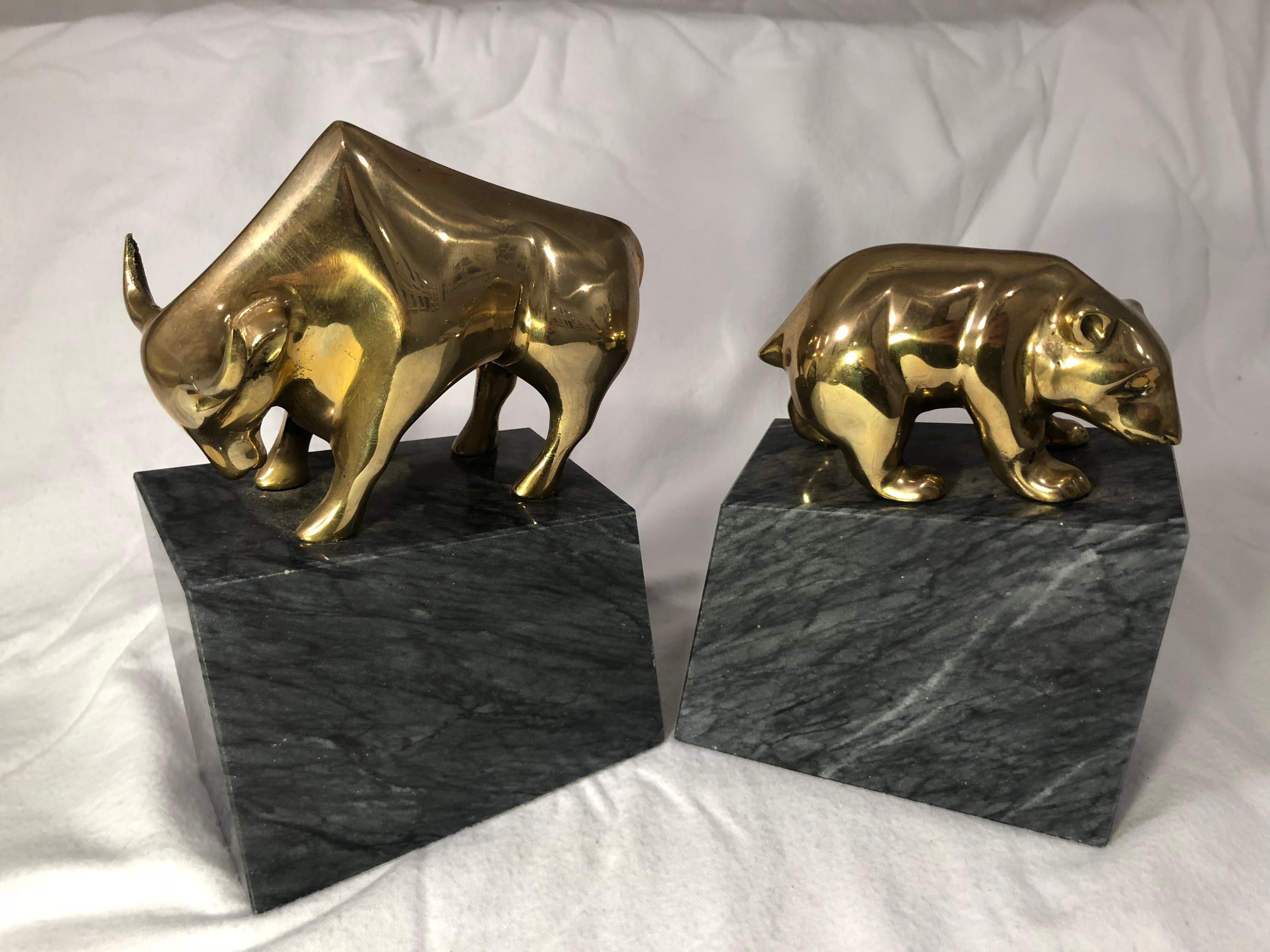 Mid-Century Modern bear and bull market bookends . Perfect gift for that wall street worker or trader on the stock market floor. Each is a cast brass design on a solid black marble base with white veining.
These are the perfect decor for a