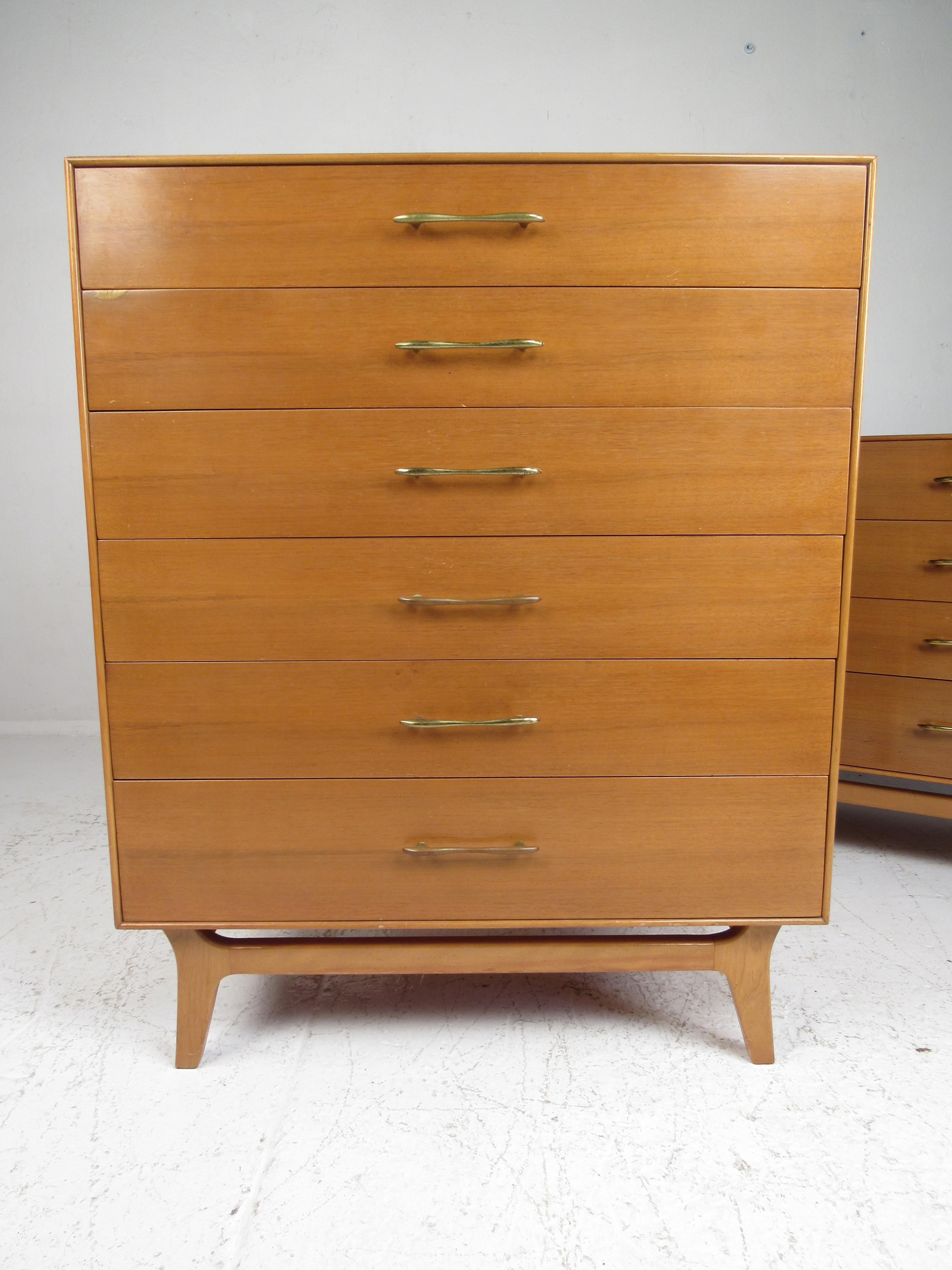 This exquisite vintage modern bedroom set includes a highboy dresser, low dresser, mirror, and a pair of nightstands. A sleek design that boasts splayed legs on a sculpted base and the iconic R-Way brass drawer pulls. This is a well made midcentury