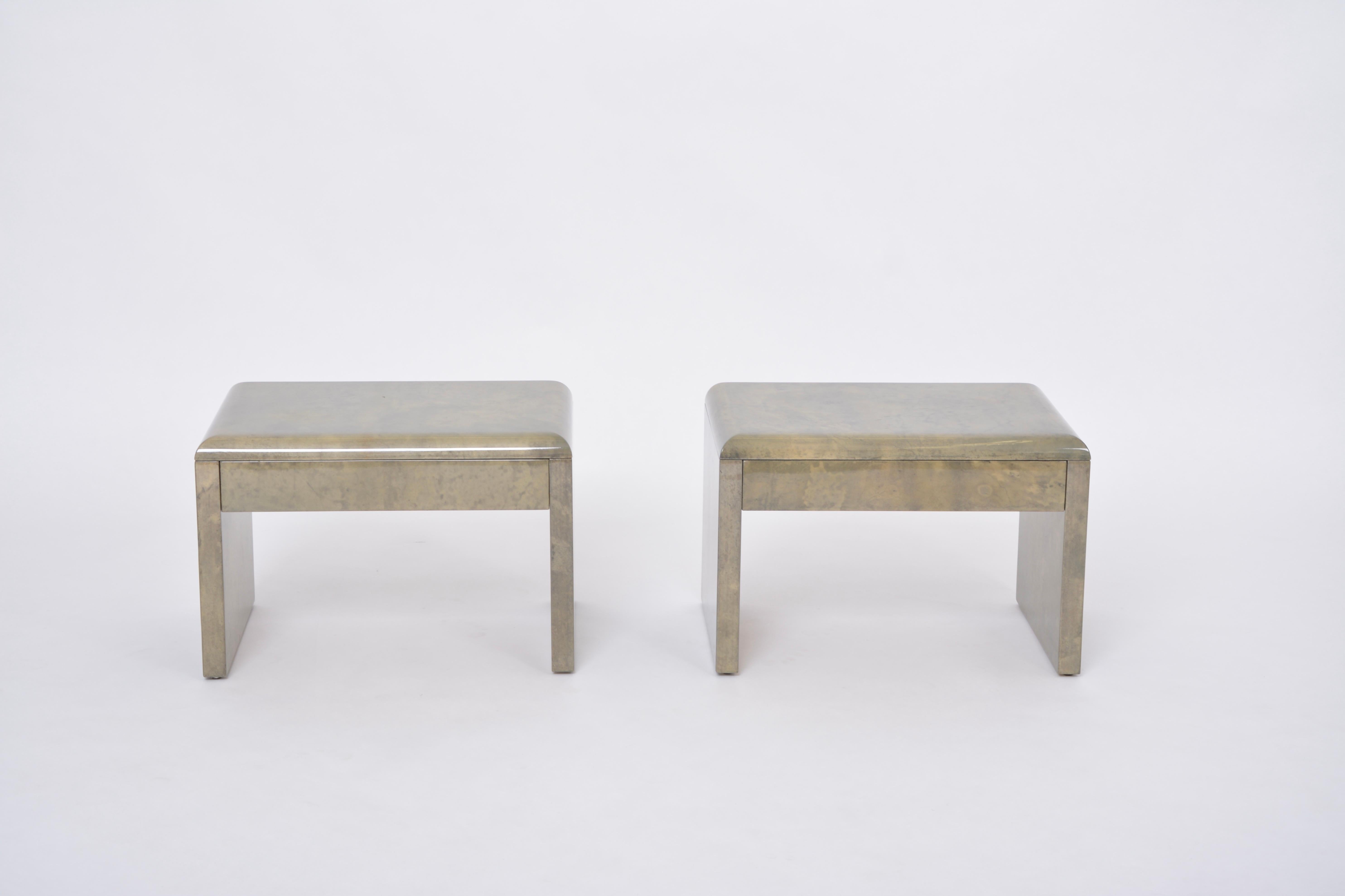 Pair of beside tables or night stands designed by Aldo Tura and produced in Italy approximately in the 1970s.
Each table has a wood structure which is covered in Aldo Tura's signature style parchment in tones of light and darker tones of green. The