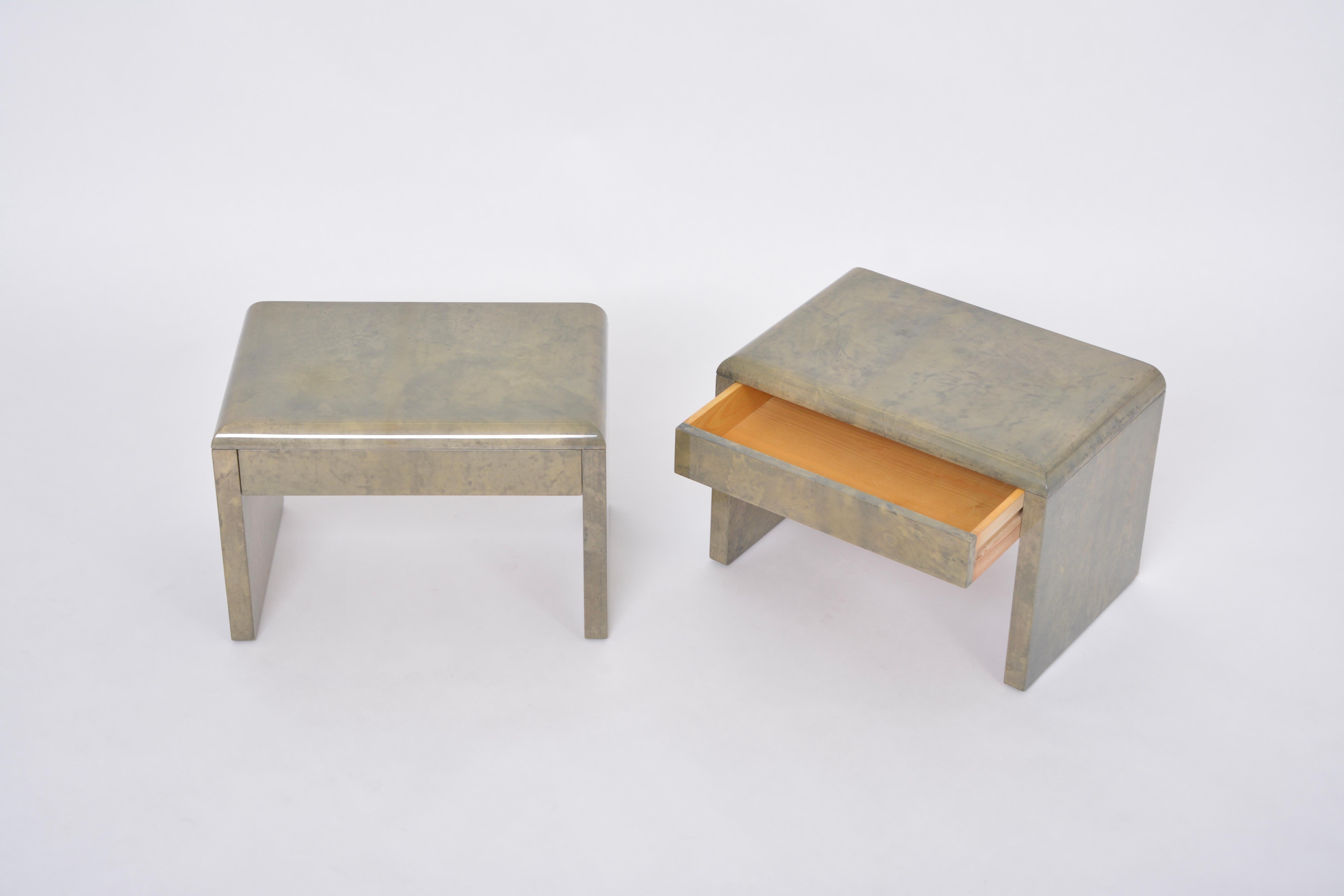 Pair of beside tables or night stands designed by Aldo Tura and produced in Italy approximately in the 1970s.
Each table has a wood structure which is covered in Aldo Tura's signature style parchment in tones of light and darker tones of green. The
