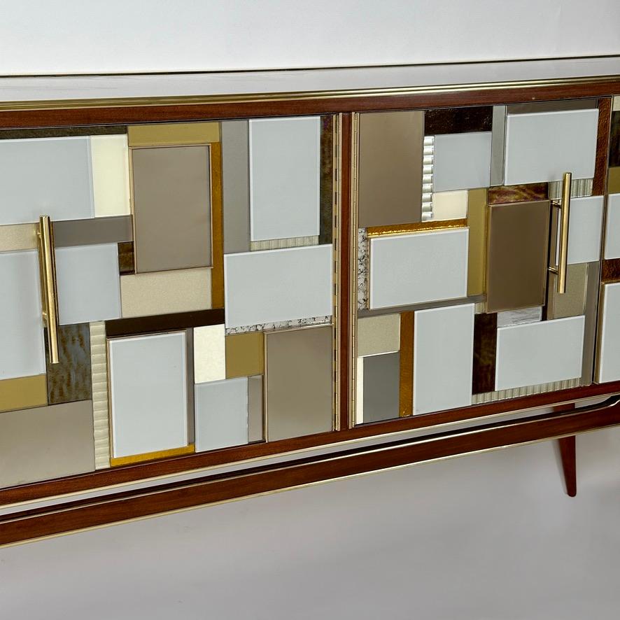 Stunning beech wood & copper mirrors credenza with brass details. 
While the five doors are covered with a bulging out marquetry mix of opaline & murano art glass (light grey, grey, gold and cream) and brass too. 
The top and the laterals of the