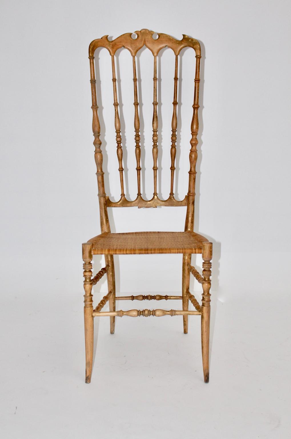 Mid Century Modern extra high back vintage side chair Chiavari from beechwood with partly gilded rests at the surface. The beautiful chair shows a hand - caned seat.

Very good vintage condition with minor signs of age. 
approx. measures:
Width: