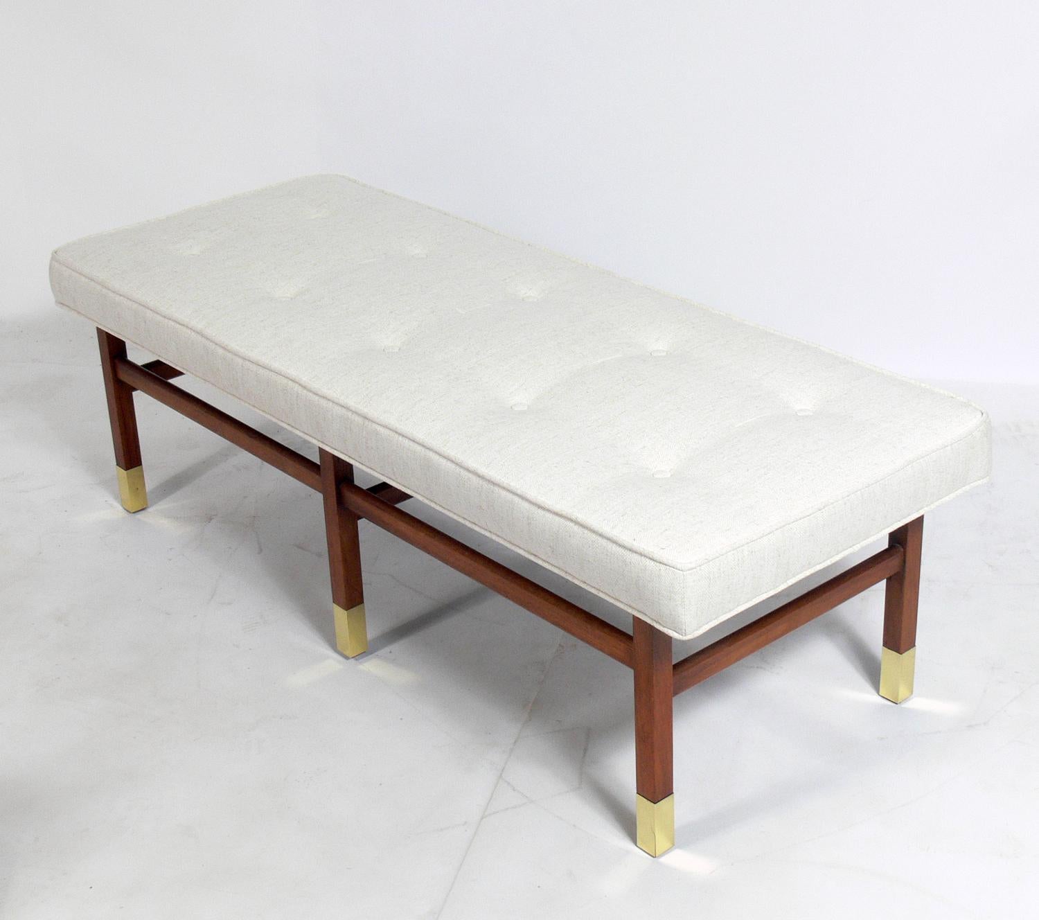 Mid-Century Modern bench attributed to Harvey Probber, American, circa 1960s. It has been reupholstered in an ivory color herringbone fabric. Brass feet have been hand polished and lacquered. Walnut has been cleaned and oiled.