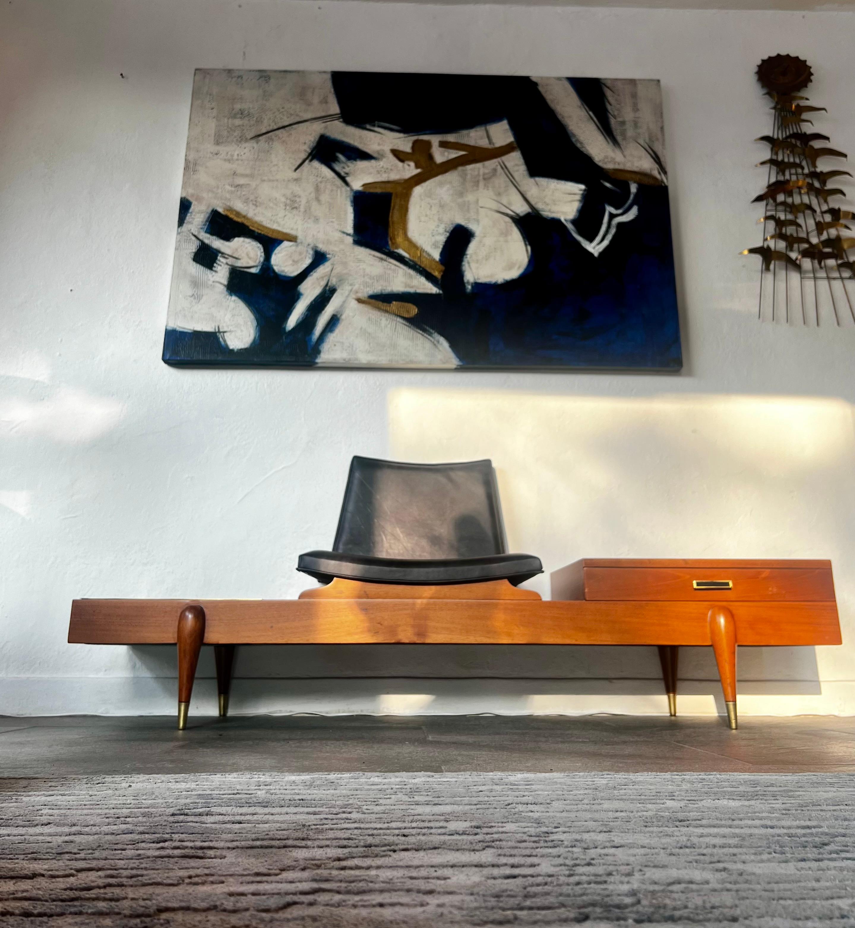 Combinaison parfaite de design et de matériaux,  cuir, laiton, bois massif et placage. Il est possible que le design ait été conçu comme un banc téléphonique ne comportant qu'un seul siège. C'est une belle pièce qui exalte notre galerie et qui
