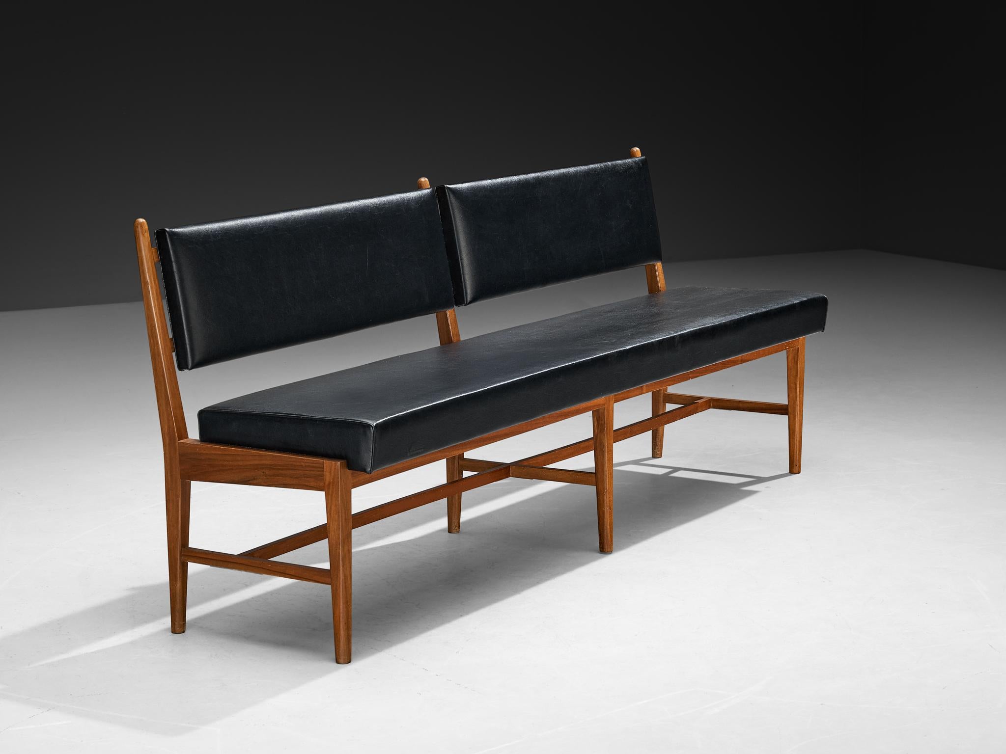 Bench, walnut, faux leather, Europe, 1950s

This European bench from the 1950s combines a walnut frame with black faux leather upholstery. The design is straightforward and functional, with a long rectangular seat and two separate backrests that