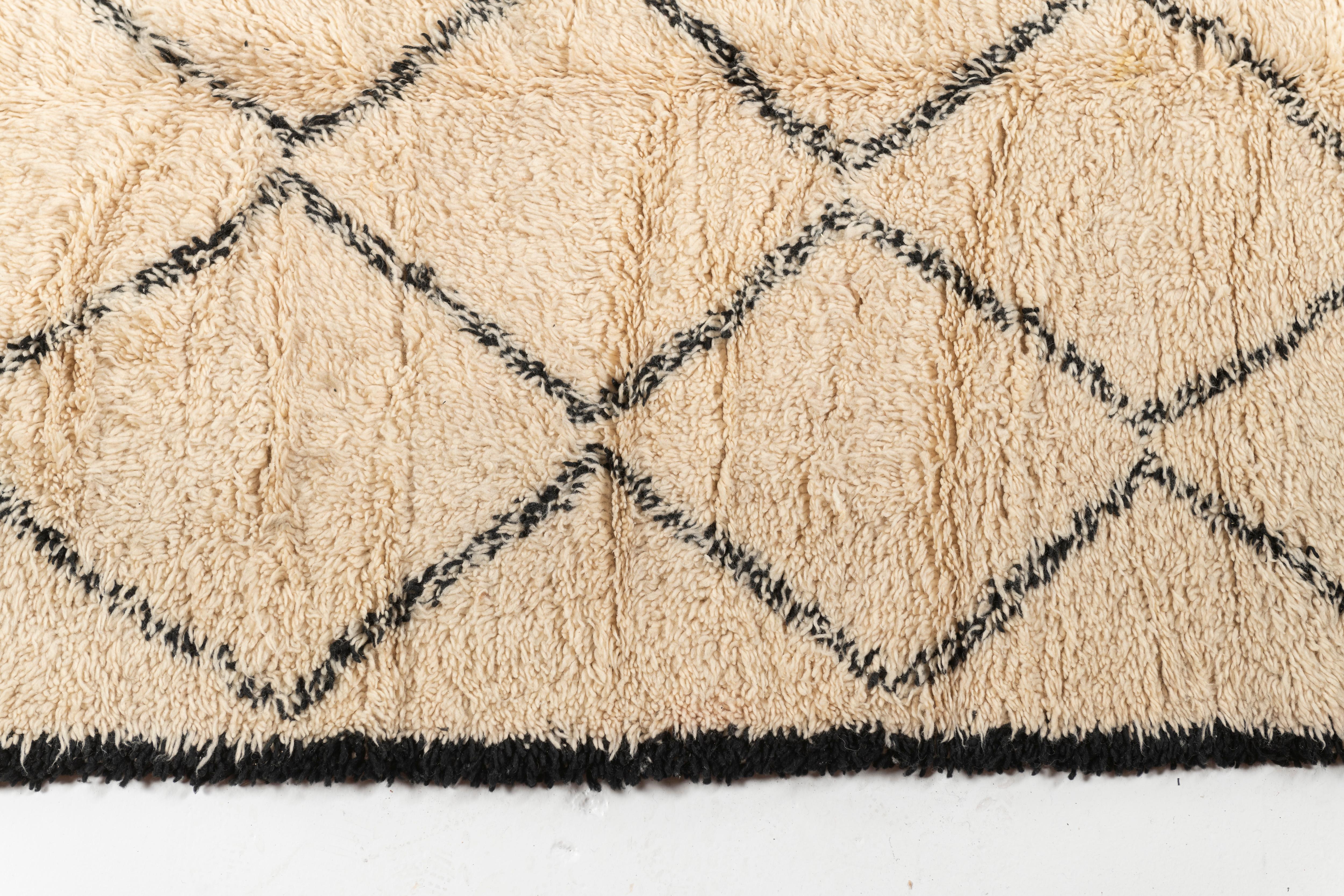 Crafted by Berber tribes in the Atlas Mountains, Beni Oourain rugs are made of natural, un-dyed wool and are hand-knotted to create a thick, plush pile. This area rug has geometric design motifs, blending traditional craftsmanship with modern