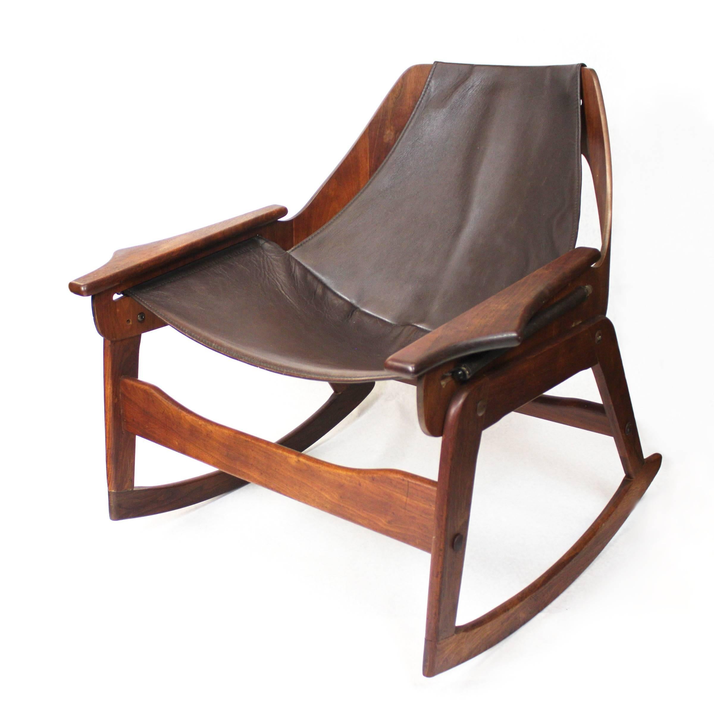 A stunning example of the 1960s original Jerry Johnson design, this rocker is a perfect mix of Classic midcentury design features. Chair features a bent walnut plywood frame supporting a deep, mocha brown leather sling cantilevered over a sculpted,