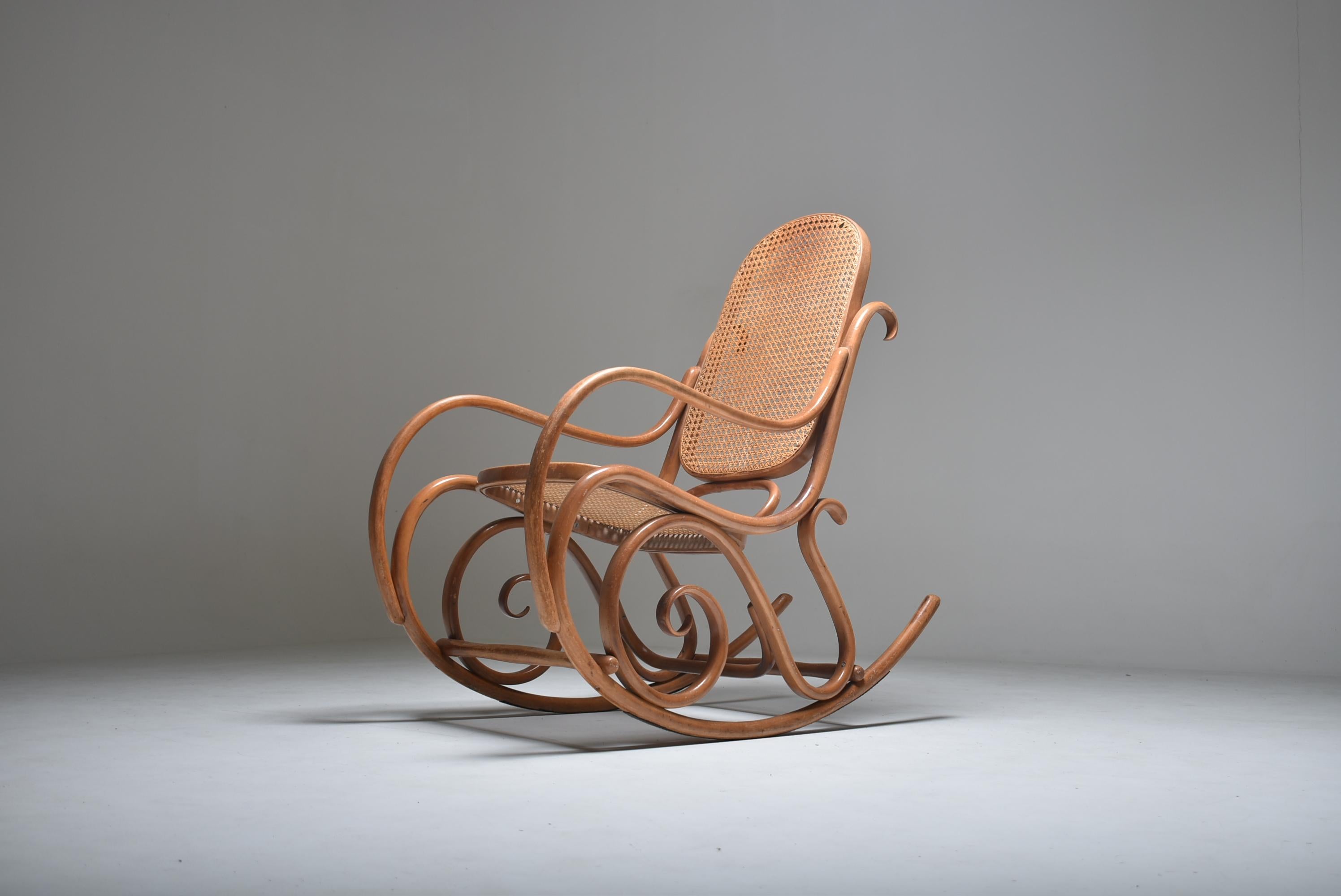 Iconic rocking chair designed by Michael Thonet, made in bent beechwood, the distinctive Thonet fabrication process.
Seat and back in cane, all in clear color.
                  