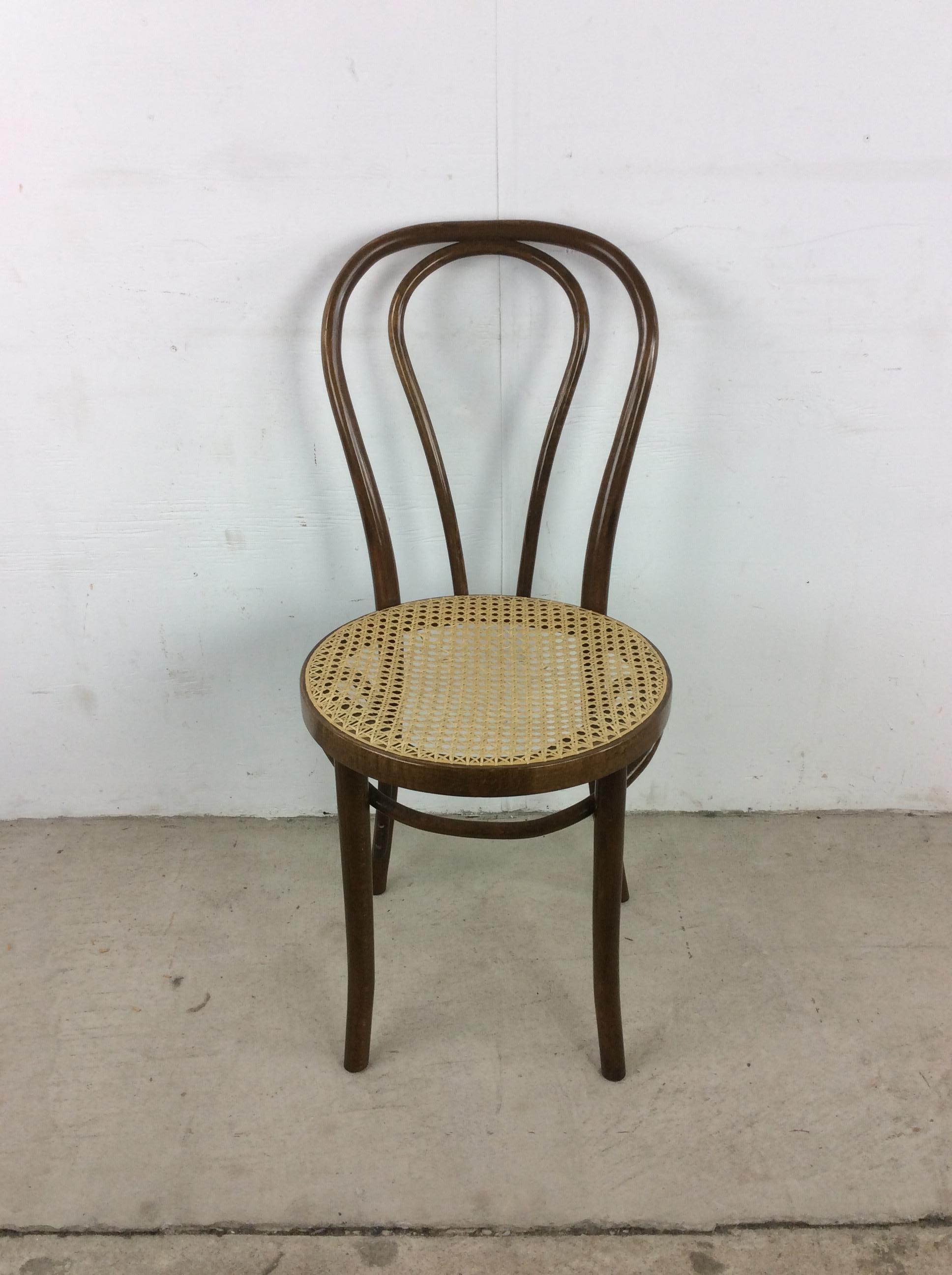 This vintage cafe chair in the style of Thonet features bentwood frame, caned seat, and tall tapered legs.  Complimentary rocking chair & bentwood ottoman available separately. 

Dimensions: 16w 17.5d 35h 18.5sh

Condition: Original finish on the