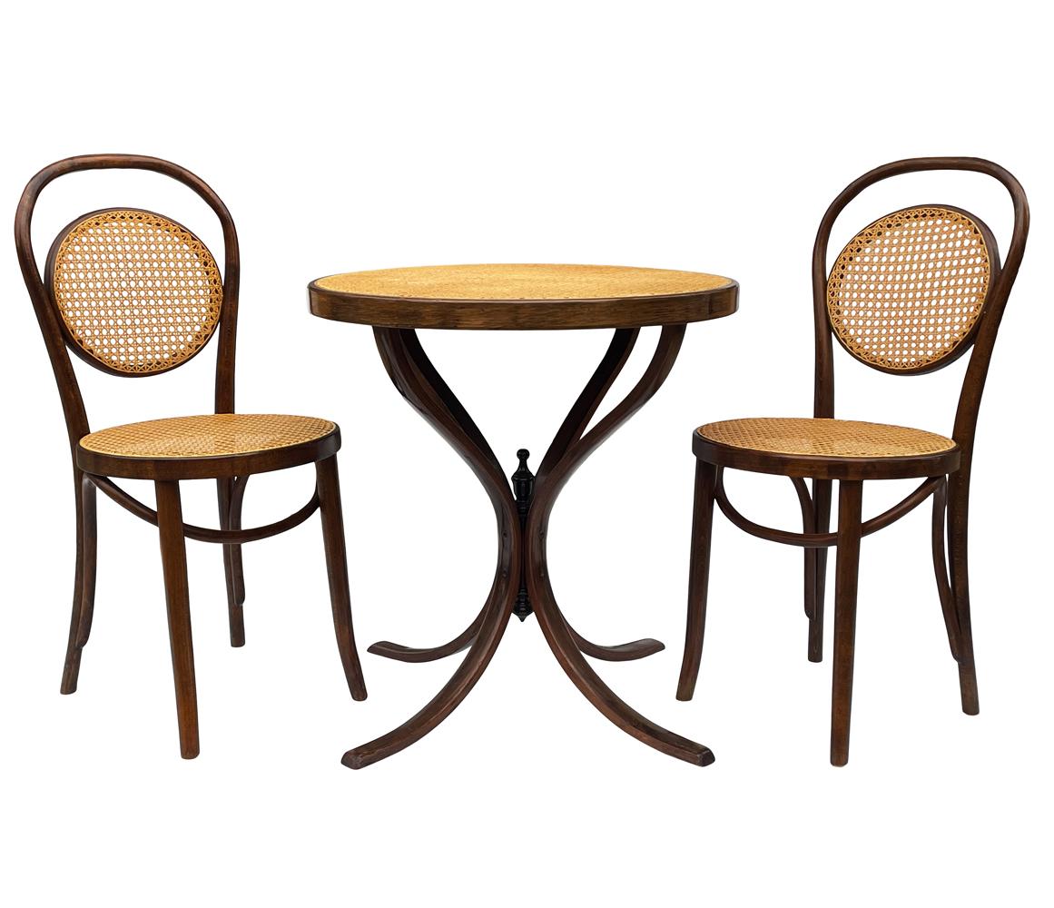 A super clean vintage bistro set consisting of two chairs & table from Czechoslovakia circa 1960's. It features beautiful solid bentwood framing with caning. Table measures 27.5 inches tall with a 26.5 inch diameter. Chairs measure H35 D18 W16 with