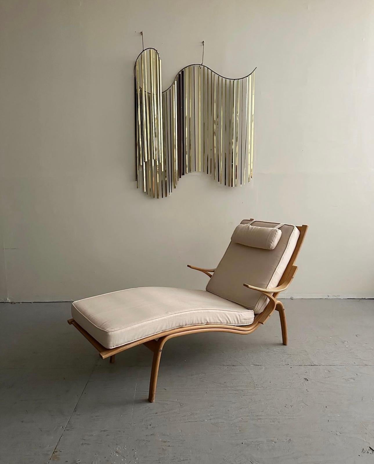 Mid-Century Modern Bentwood Chaise Lounge Designed by Alvar Aalto For Artek. This bentwood chaise lounge is made of solid birch wood and features two removable off white seat cushions and a matching adjustable headrest. Made in Sweden, Circa 1960s.