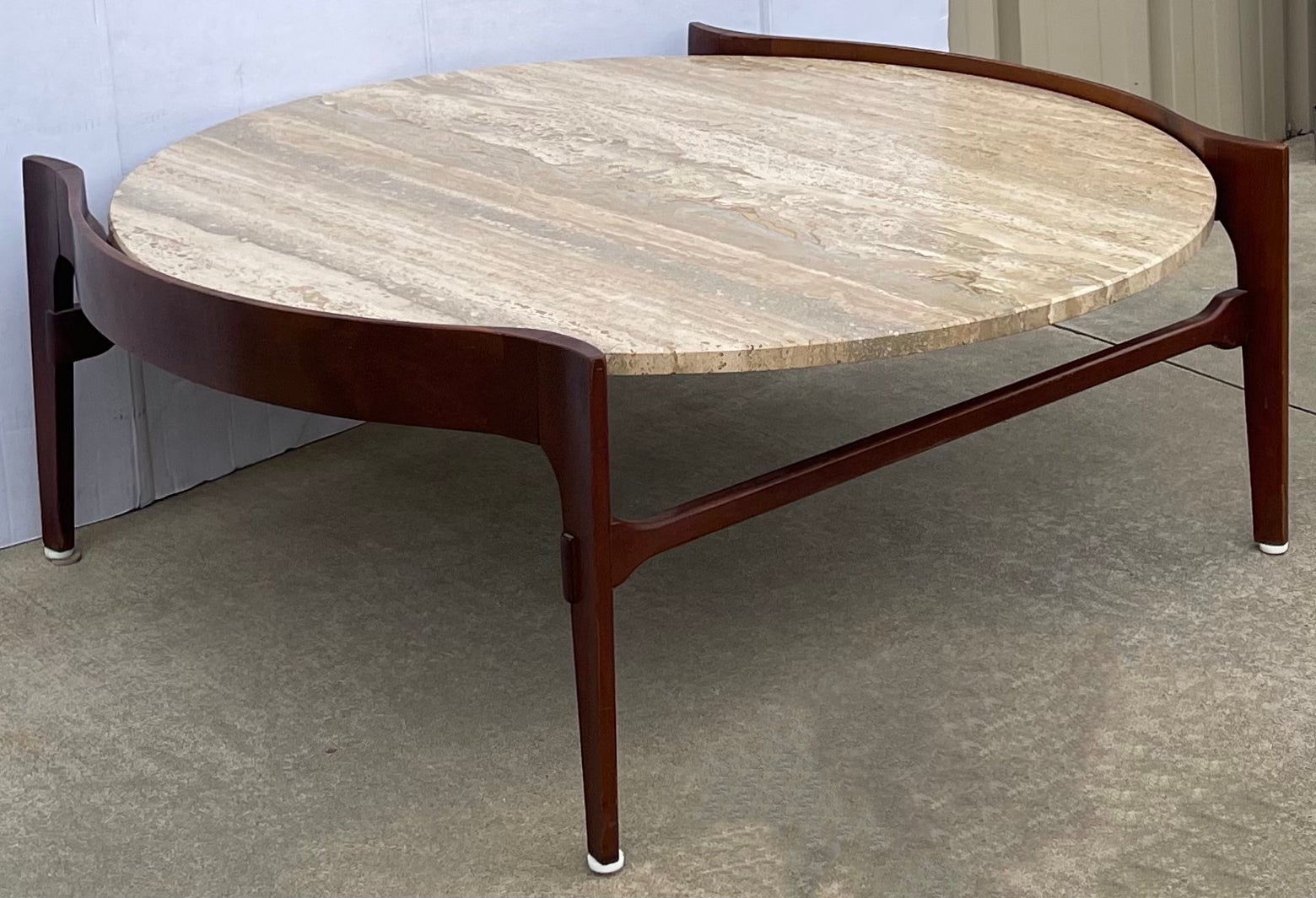 Love this! It is a Coffee table with a sleek hand carved walnut frame and a drop in travertine top. It is of the Mid-Century Modern period, and it was designed by Bertha Schaefer for M. Singer & Sons.