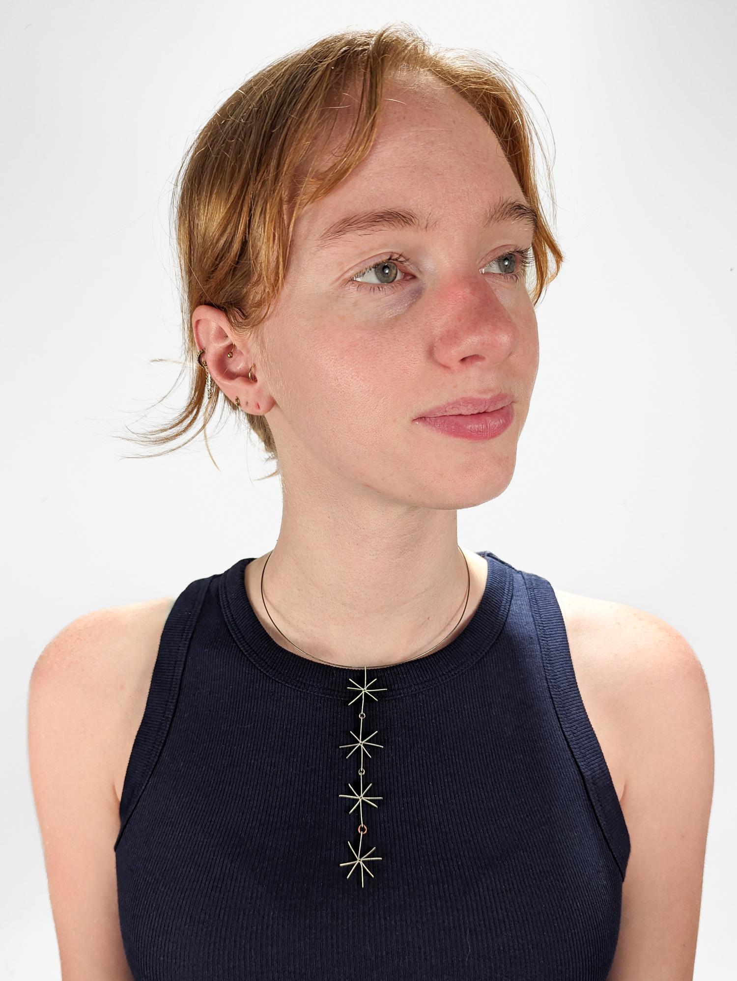 A fine Modernist silver necklace.

In the style of Betty Cooke.

With silver wire starbursts linked together in a 4-link pendant suspended from a twisted wire choker necklace.

Unmarked.

Simply wonderful Mid-Century design!

Date:
Mid-20th