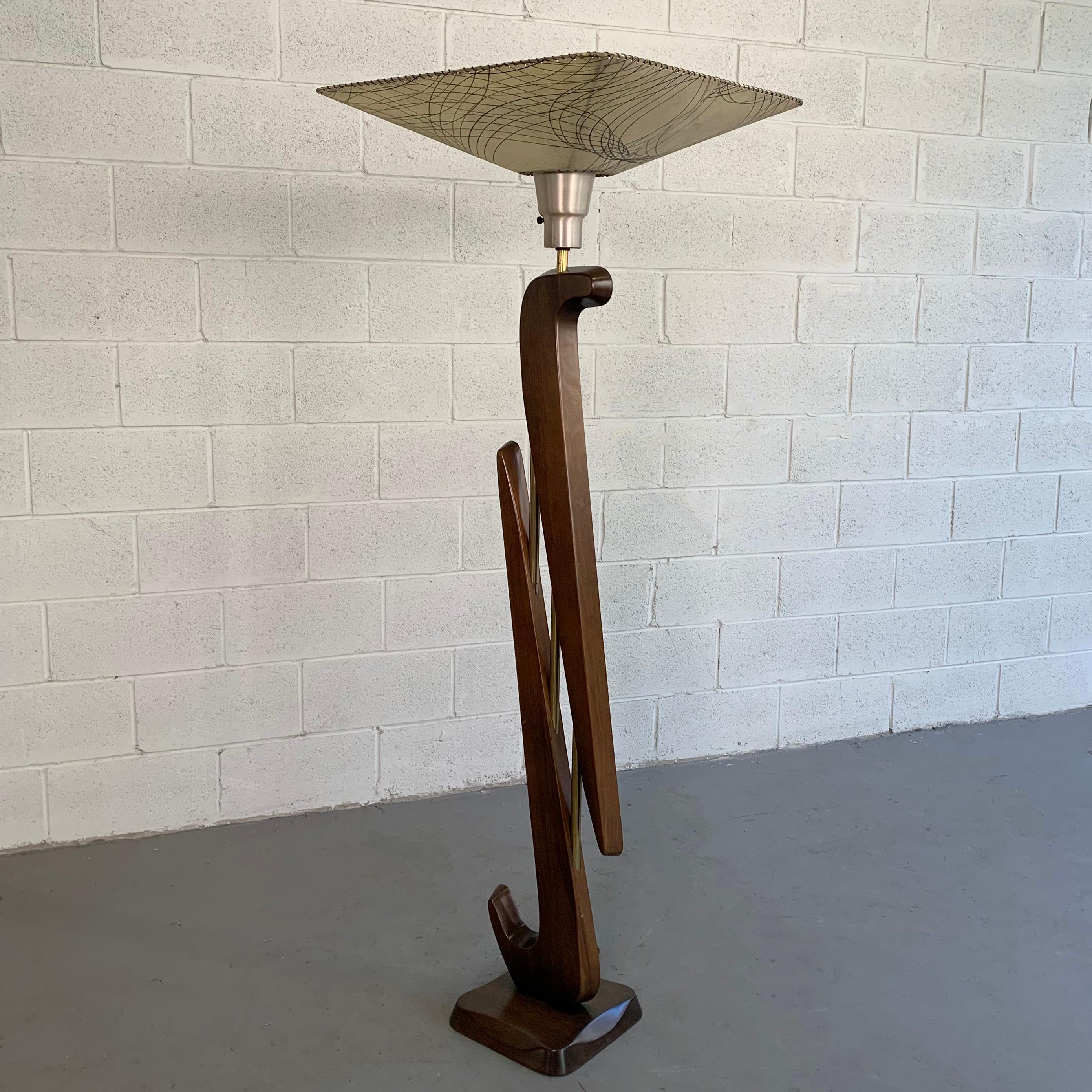 Monumental, Mid-Century Modern, torchère, floor lamp attributed to Modeline Lamp Co., features a sculptural, biomorphic, mahogany base with brass accents, spun aluminum socket with it's original parchment shade. The lamp accepts a large socket mogul