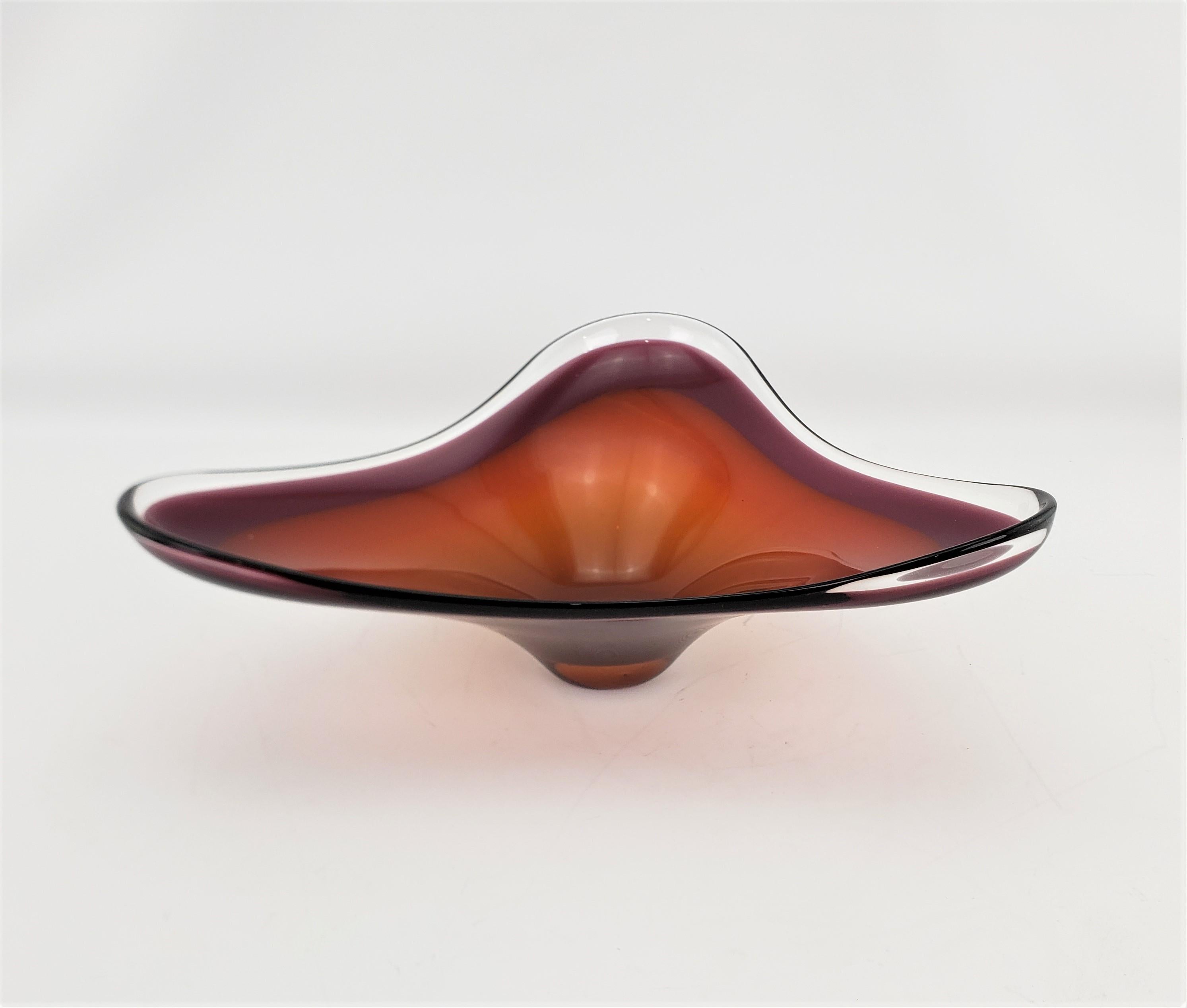 This large and substantial biomorphic shaped art glass bowl is unsigned, but presumed to have been made in Scandinavia, likely Sweden, in approximately 1970 in the period Mid-Century Modern style. The bowl or centerpiece, given its size, is done