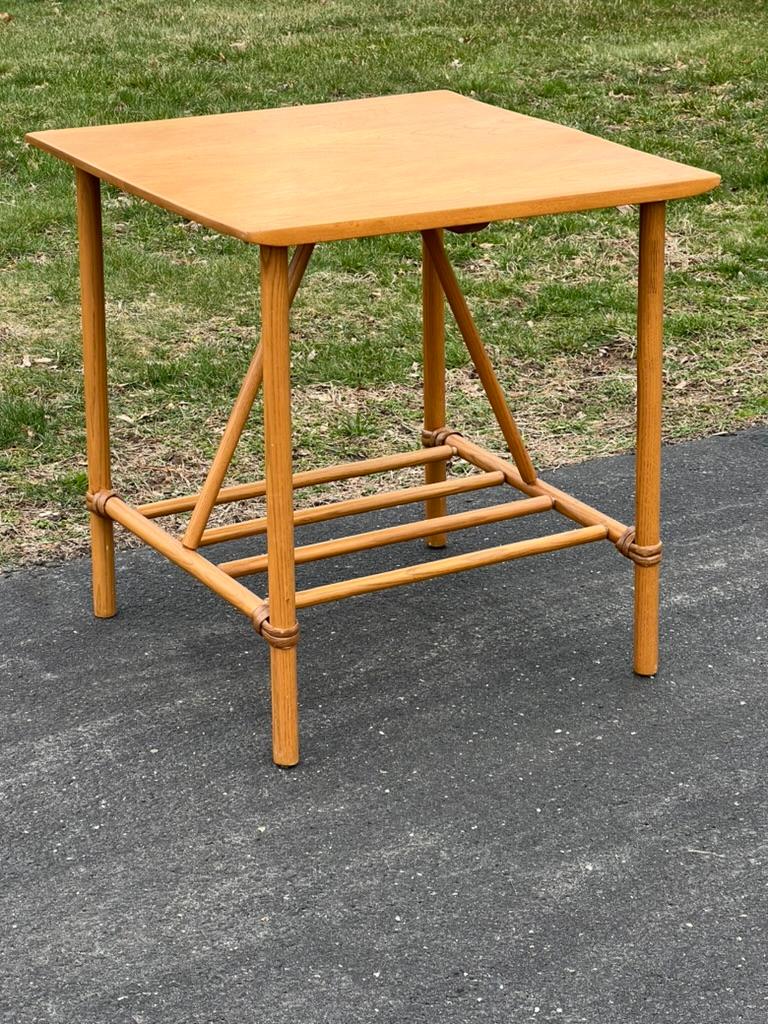 Der Mid-Century Modern Accessoire-Tisch aus Birke und Rattan von Heywood Wakefield ist die Quintessenz eines Stücks, das organische Wärme mit elegantem Design verbindet. Der mit viel Liebe zum Detail gefertigte Tisch besteht aus einem Gestell aus