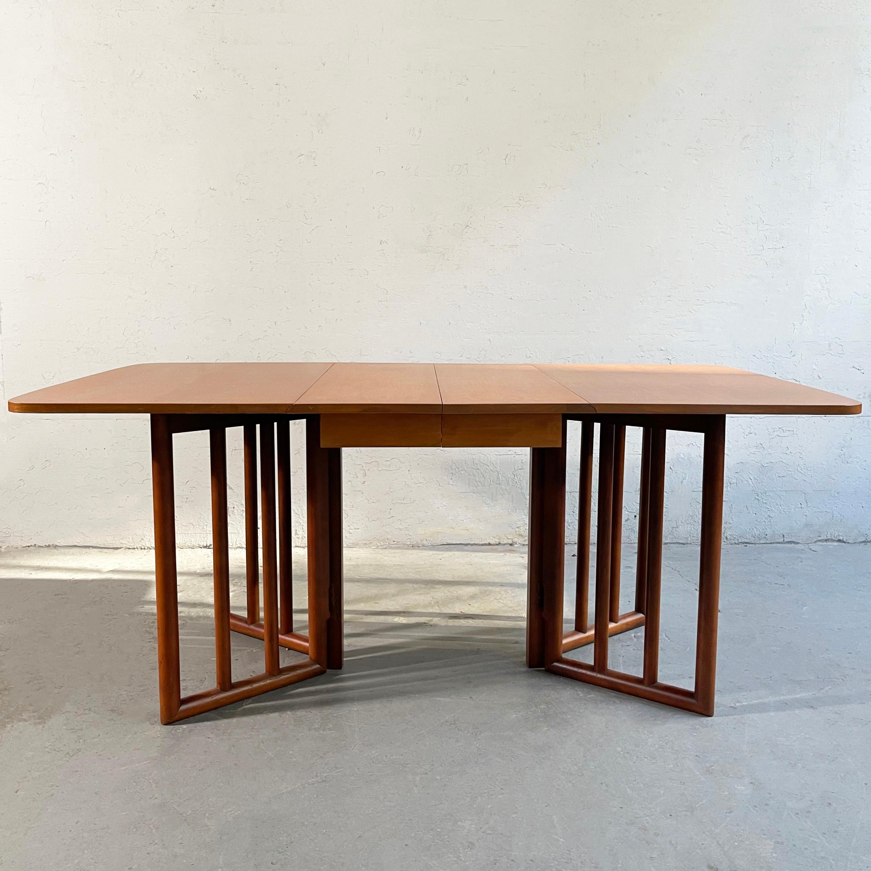 Mid-Century Modern, birch, drop leaf dining table attributed to T.H. Robsjohn Gibbings feautures an architectural, columnar, gate leg base. This versatile table can also be used with one leaf up and folds down completely to a 38 x 25.5 inch deep