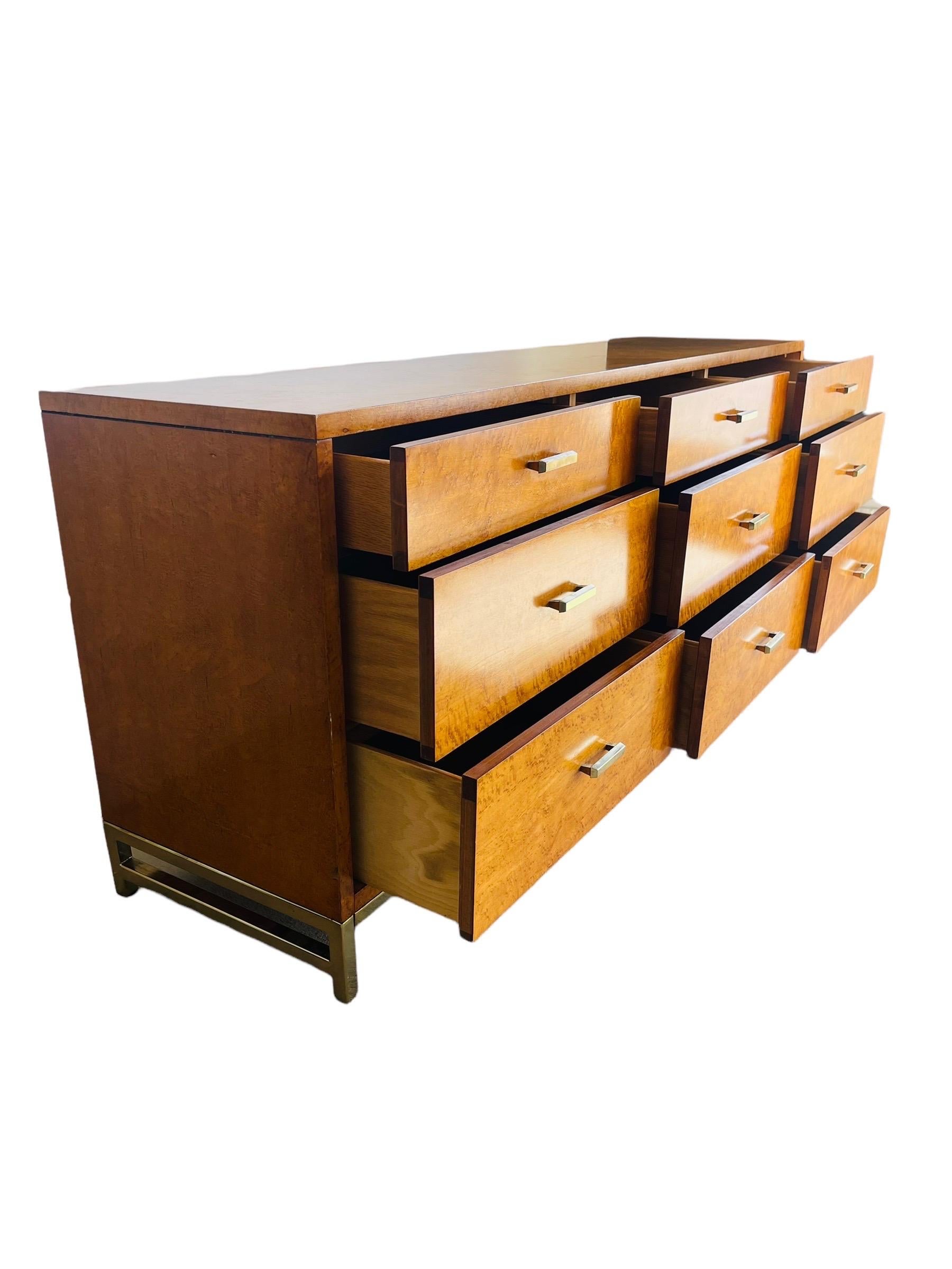 Stunning Mid-Century Modern birdseye maple dresser by Milo Baughman for Lane Furniture. This dresser is equipped 9 drawers and brass drawer pulls and base. The dresser is in good vintage condition with normal wear consistent with age and use.