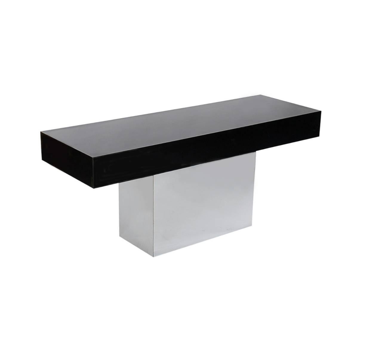 A chic and sophisticated console in the manner of Milo Baughman. It consists of a thick and chunky high gloss black top with a chrome base. It's been very well cared for through the years and ready for immediate use.