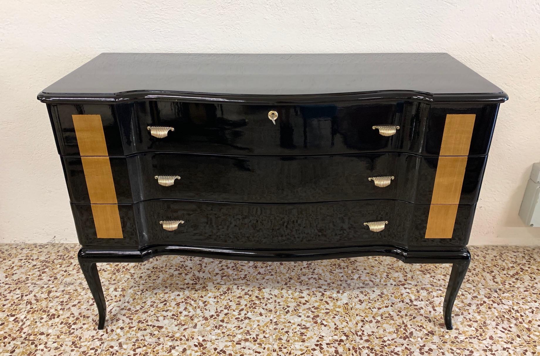 This dresser was produced in the 1950s in Italy.
It is completely black lacquered while the front is decorated with gold leaf.
The brass handles complete the elegance of the dresser.
