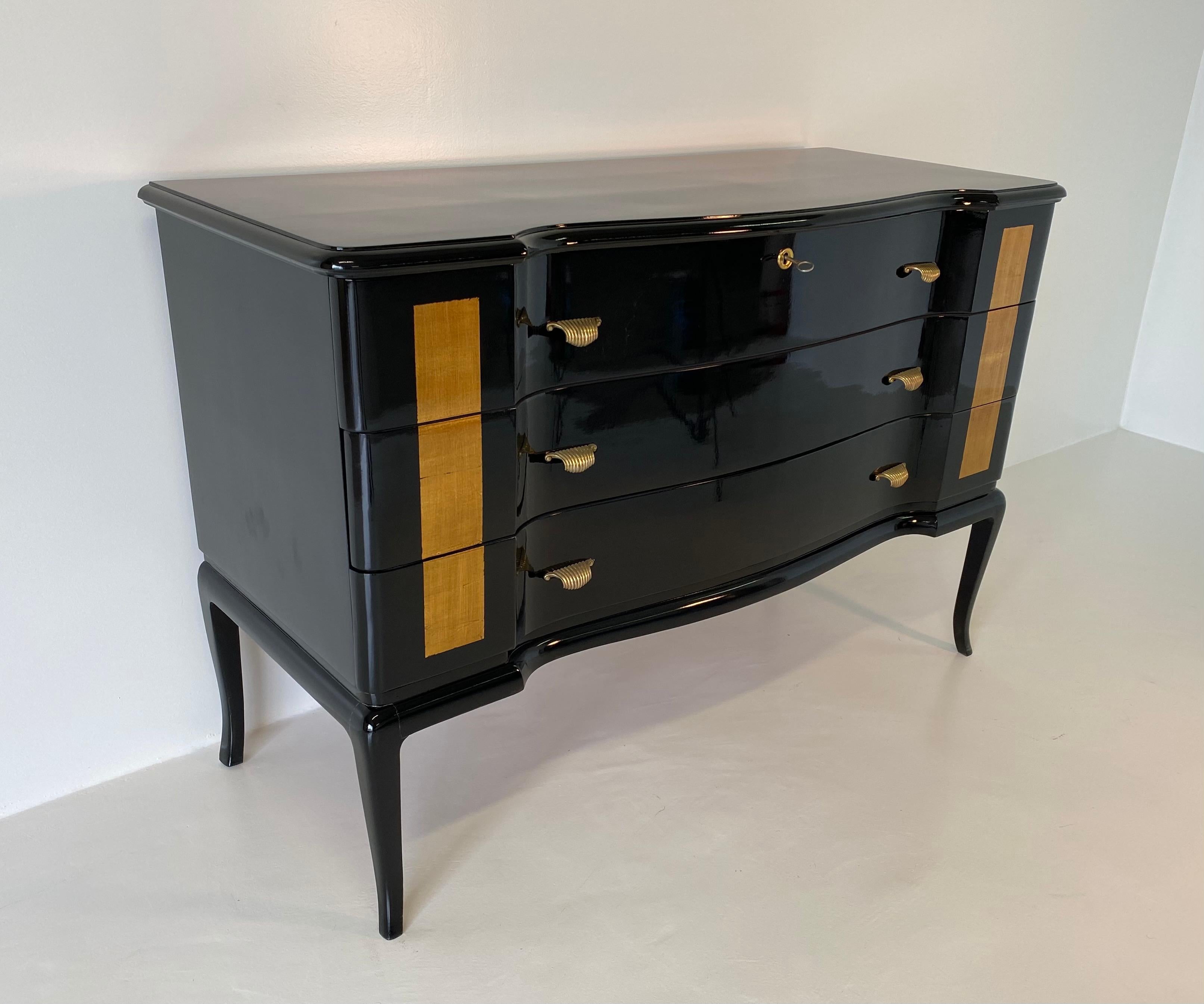 This dresser was produced in the 1950s in Italy.
It is completely black lacquered while the front is decorated with gold leaf.
The brass handles complete the elegance of the dresser.