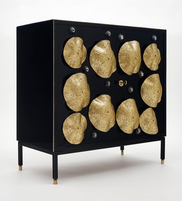 Italian buffet is from the Veneto region of Italy. This Mid-Century Modern piece has been customized to a neo-baroque style. This charming small buffet was fully restored, ebonized, and finished with a black Murano glass veneer. The cabinet features