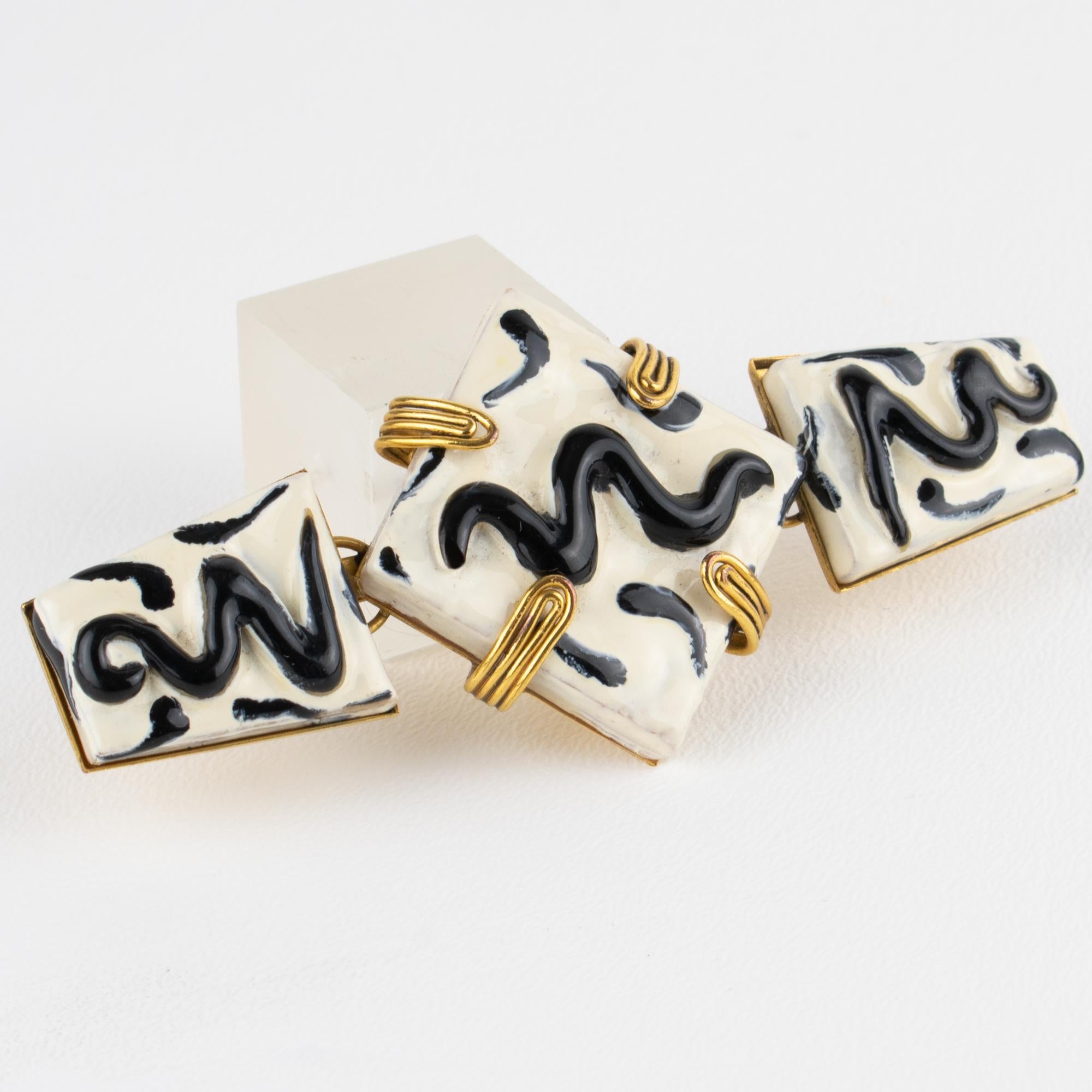Esempio straordinario di arte francese di metà secolo, questa spilla scultorea in ceramica è un vero gioiello da collezione. Incorniciato in un'audace cornice geometrica in ottone dorato, il raro pezzo mette in mostra tre elementi in ceramica ornati