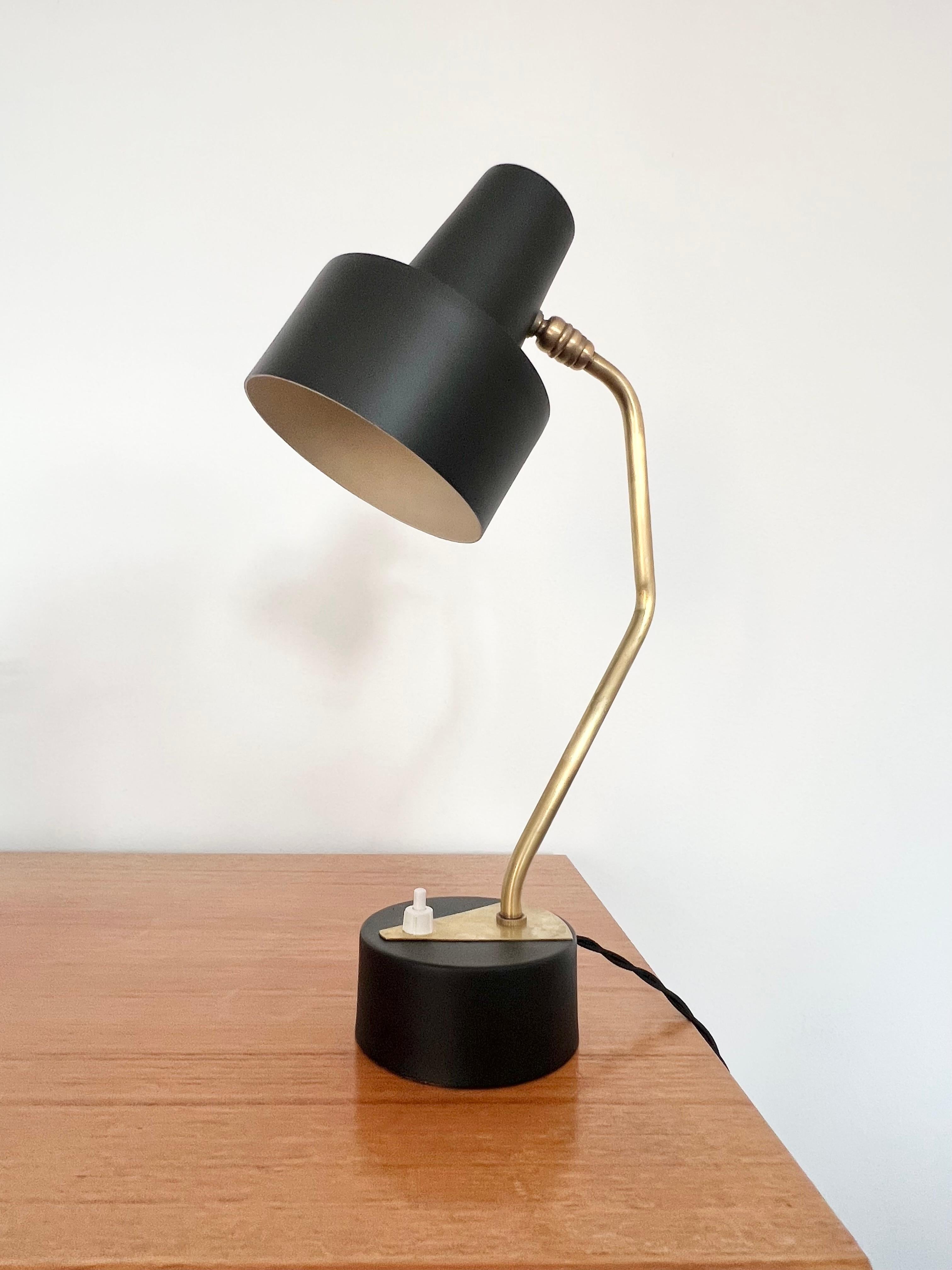 Mid century black & brass adjustable desk lamp attributed to Pierre Guariche for Disderot, France in the 1950's.

 
A long black adjustable shade on a fixed brass stem, mounted on a circular base.

 
Good vintage condition with some minor marks to
