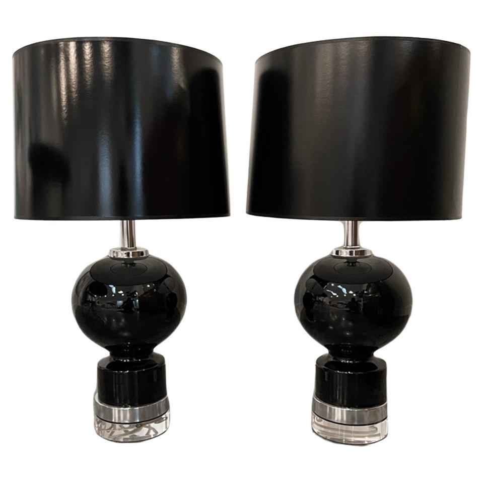 A pair of stunning Mid-Century Modern shiny black glazed ceramic table lamps with chrome plate accents and and Lucite bases and Lucite final. The Lucite base under the chrome makes the lamps taller and more chic, but is not attached and can be