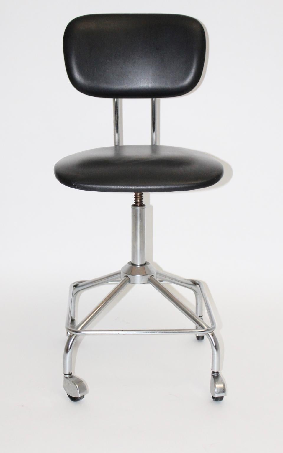Mid Century Modern vintage desk chair designed by Egon Eiermann. The desk chair features a chromed metal base with 4 wheels. Also the seat and back, made of plywood, were covered with black faux leather. The seat is adjustable from up to down.
The