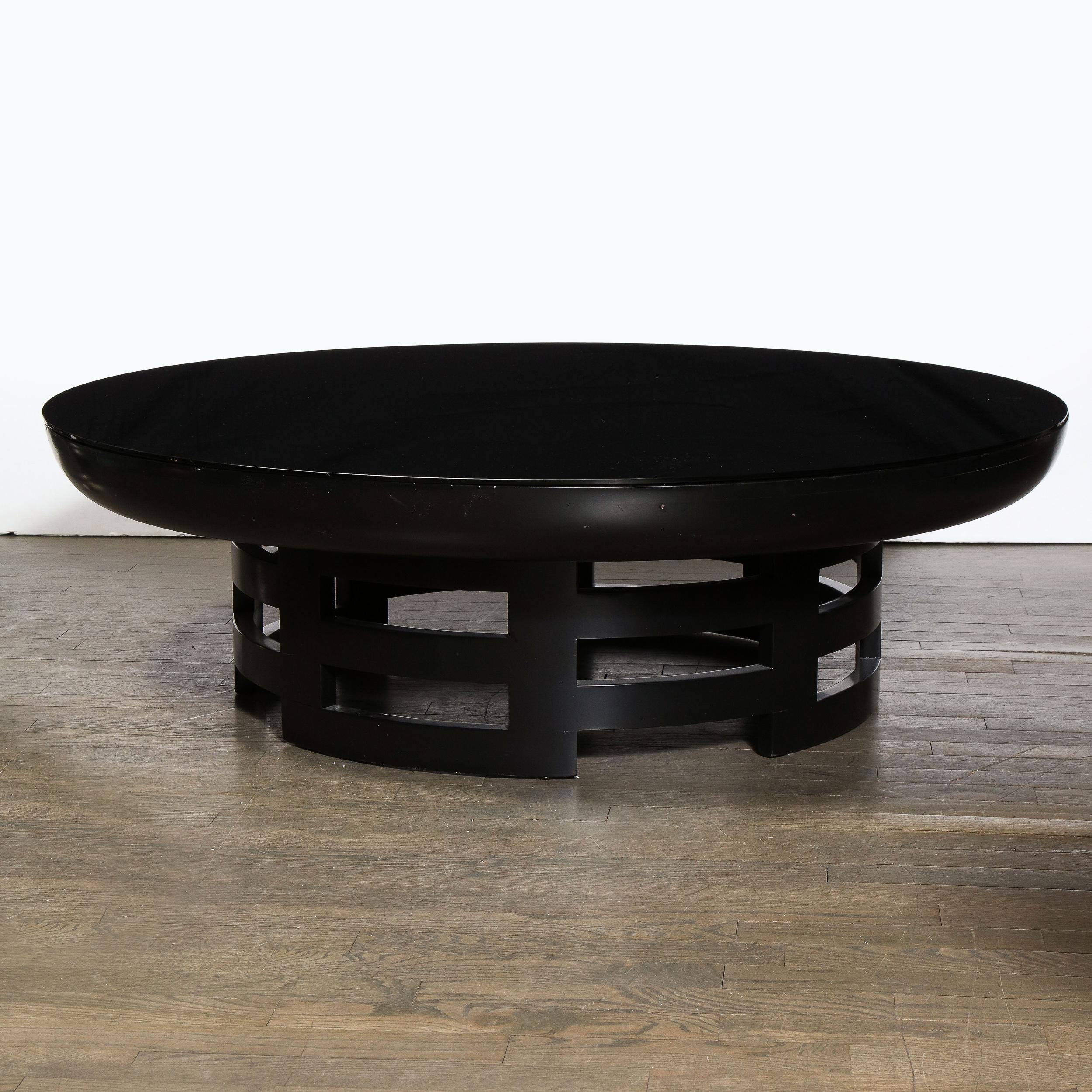 This elegant Mid-Century Modern cocktail table was realized the esteemed Muller & Barringer for Kittinger in the United States, circa 1950. It features a sculptural rectilinear base in ebonized walnut consisting of adjoining rectilinear forms that