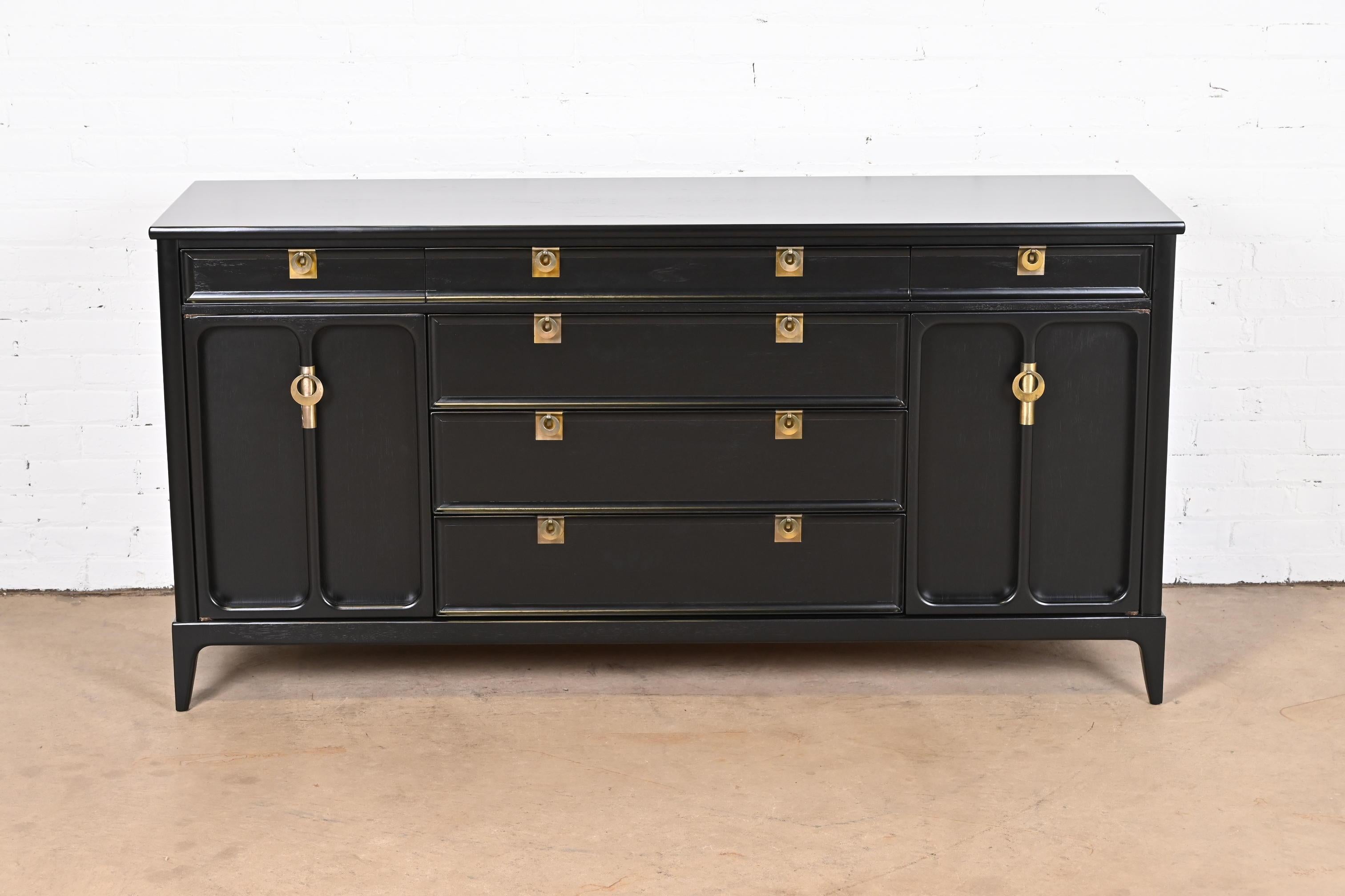 An exceptional Mid-Century Modern Hollywood Regency sideboard, credenza, or bar cabinet

By White Furniture

USA, 1950s

Black lacquered walnut, with original brass hardware.

Measures: 66.75