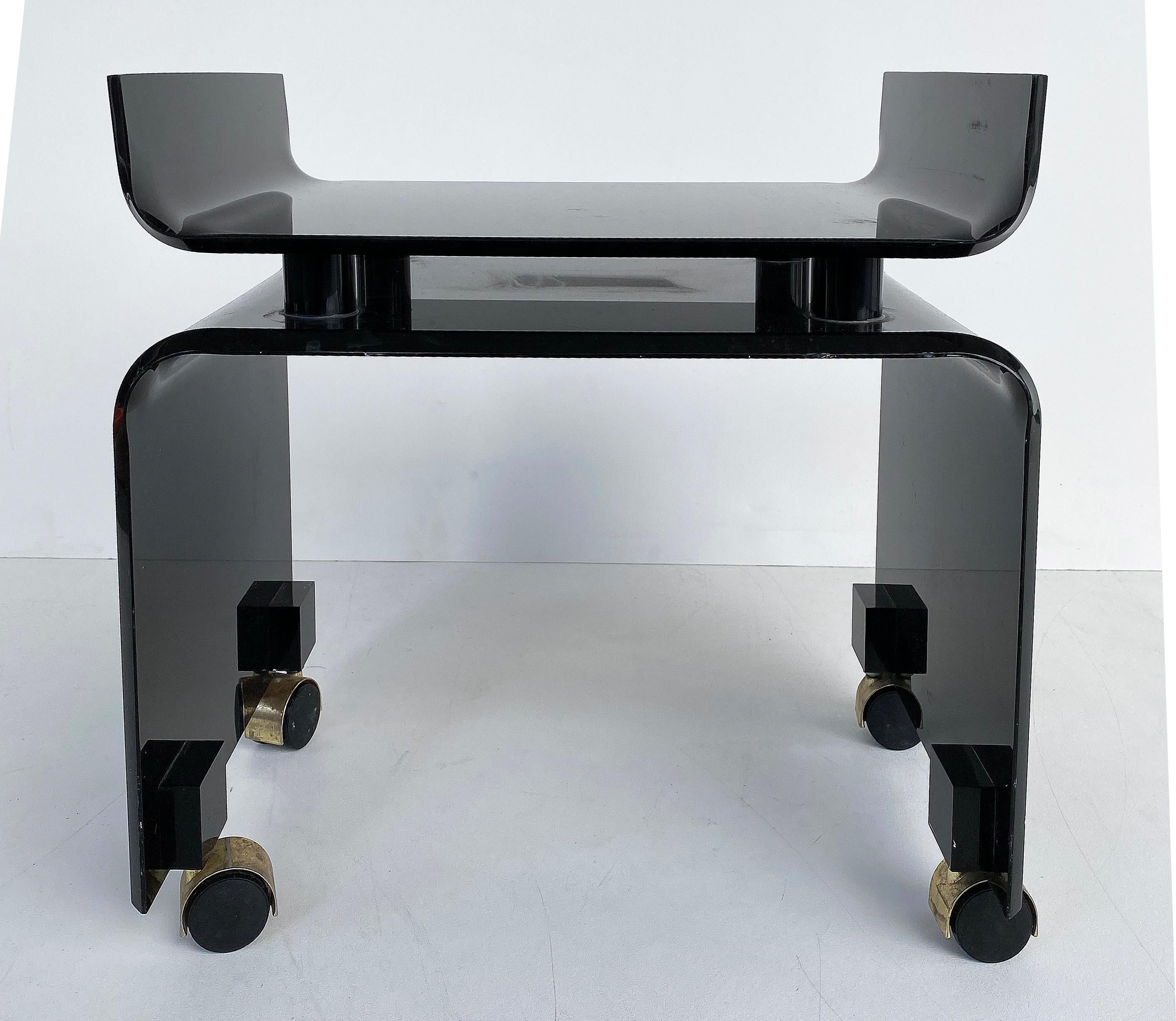 Mid-Century Modern black Lucite vanity bench on casters

Offered for sale is a black Lucite acrylic vanity bench on casters. The casters are gold-tone. The bench has curved sides on top that are designed to hold a thick custom made upholstered