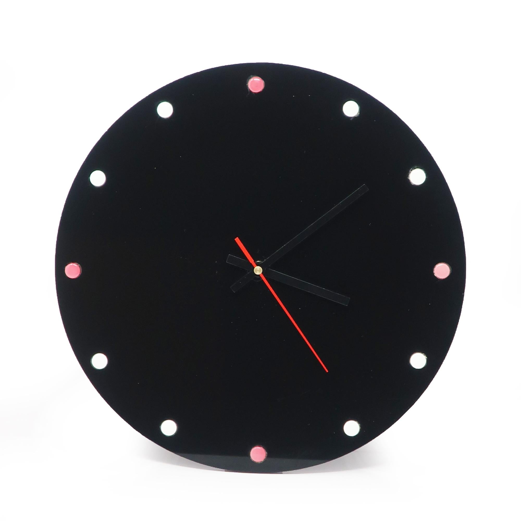 A sophisticated but perficlty simple black lucite wall clock.  Black face, black and red hands, and pink and white dots for numbers.  Minimalism at its finest!

In good vintage condition with wear consistent with age and use.

12