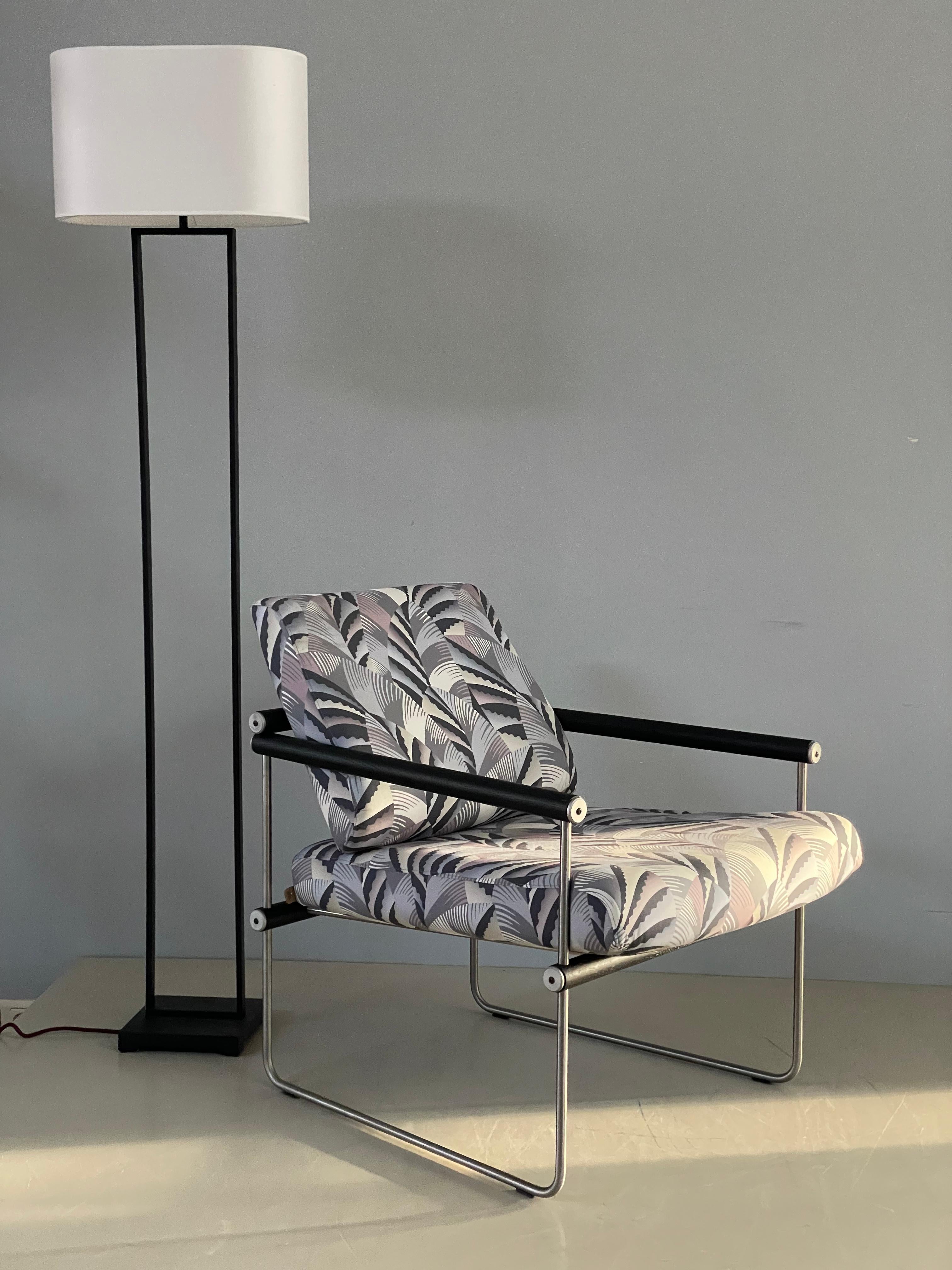 A Mid-Century Modern comfortable armchair - designed and locally produced by Ghyczy in the Netherlands. The armrests are made of solid black oak wood. The Frame of the armchair is made of stainless steel. The chair looks airy and and elegant and is