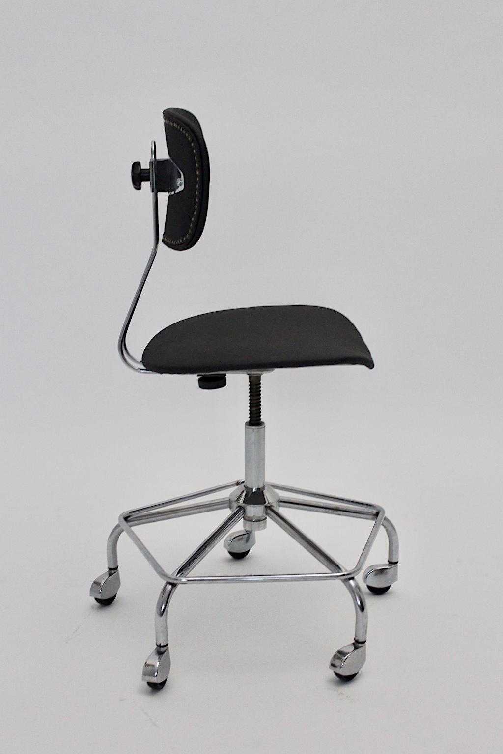 Mid-Century Modern vintage black desk chair of office chair or swivel chair, which was designed in the style of Egon Eiermann, Germany 1950s.
The swiveling desk chair is adjustable from up to down. The chromed metal base shows five chromed wheels