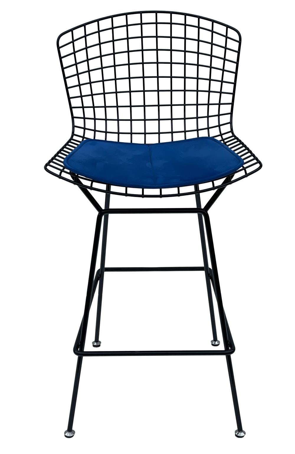 A classic design by Harry Bertoia for Knoll. It features a black powder coat frame with blue suede seat cushion. Manufacturer stamp on frame.