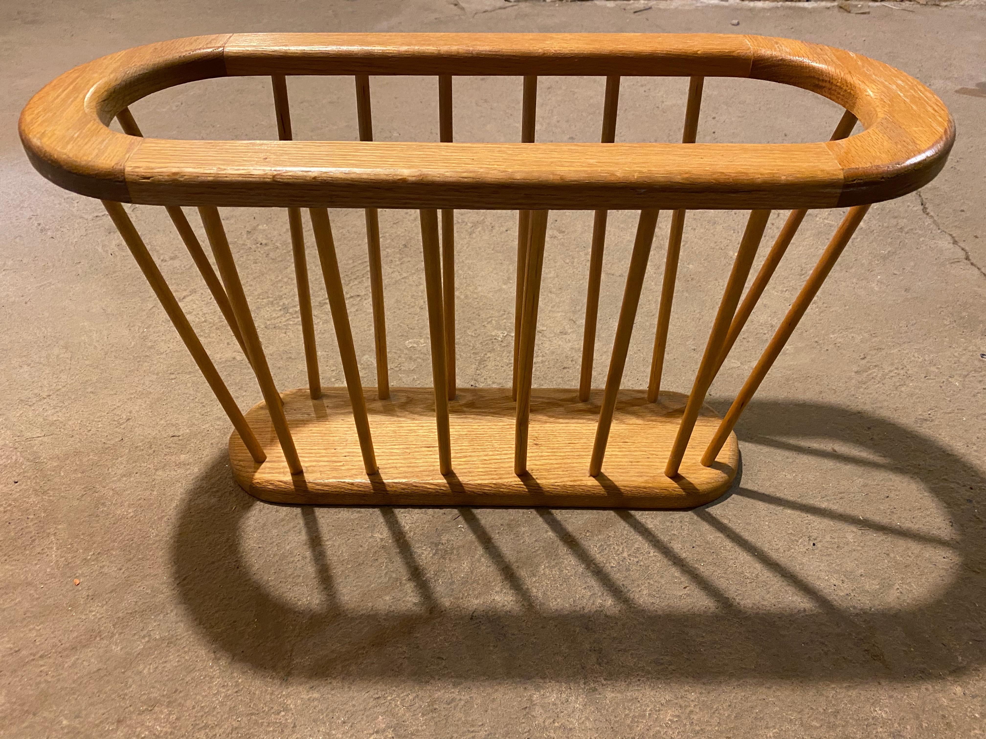 Mid-Century Modern Blonde magazine rack. Oval shape with spindles in mid-century style.
