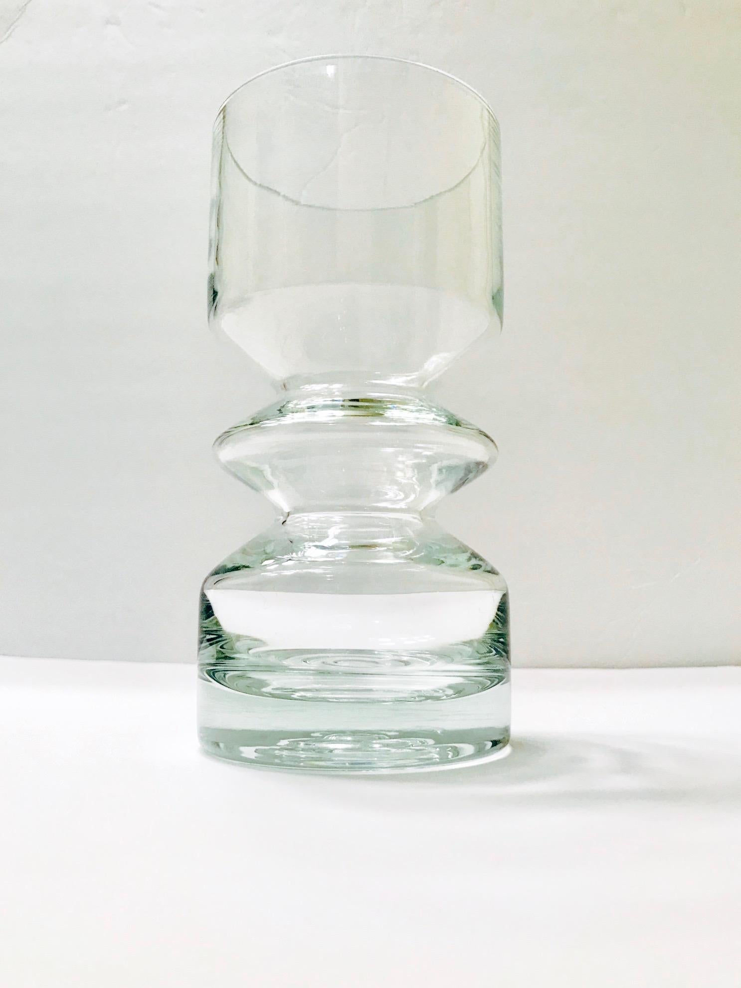 Gorgeous Mid-Century Modern clear blown glass vase. Vase has sculptural cylinder form with hooped center and tapered base design. Designed by Tamara Aladin for the iconic Riihimäen Glass company of Finland. Riihimäen Glass was in production from