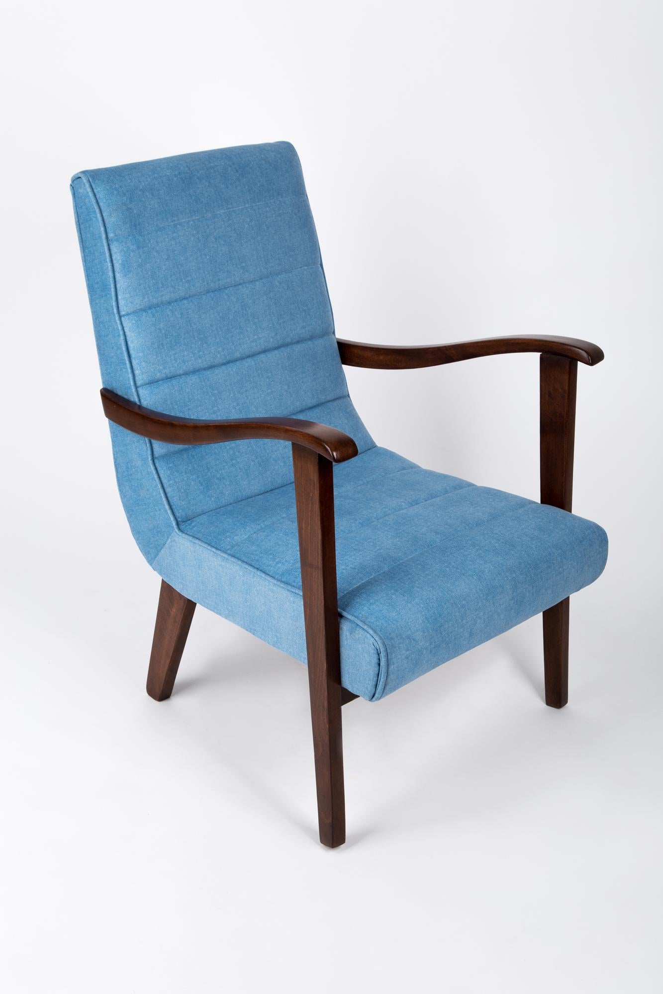 A vintage armchair, manufactured in the 1960s in Poland by the Prudnik Furniture Factory. The armchair is after full upholstery and carpentry renovation. The upholstery structure resembles denim. The wooden structure is covered with a dark-brown