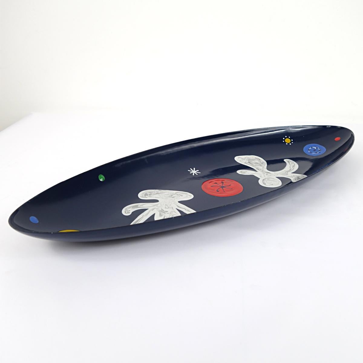 Beautiful blue steel bowl with surreal colorful decorations in virgin white, blood red and jersey yellow.
It was made in the 1950s by A.N.M.B. (Algemene Nederlandse Metaalwerkers Bond, the General Netherlands Steelworkers Union).
Its design is