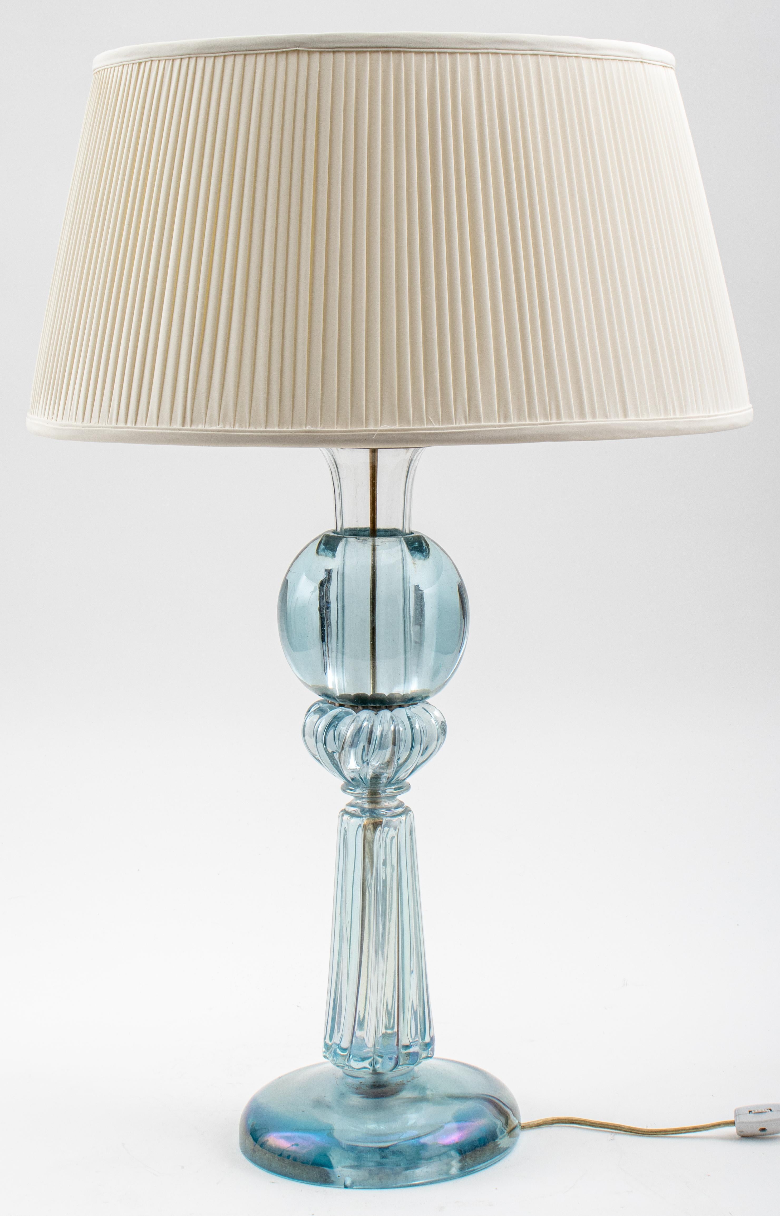 Mid-Century Modern blue glass table lamp with an iridescent finish, together with a white cloth lampshade. Measures: 28